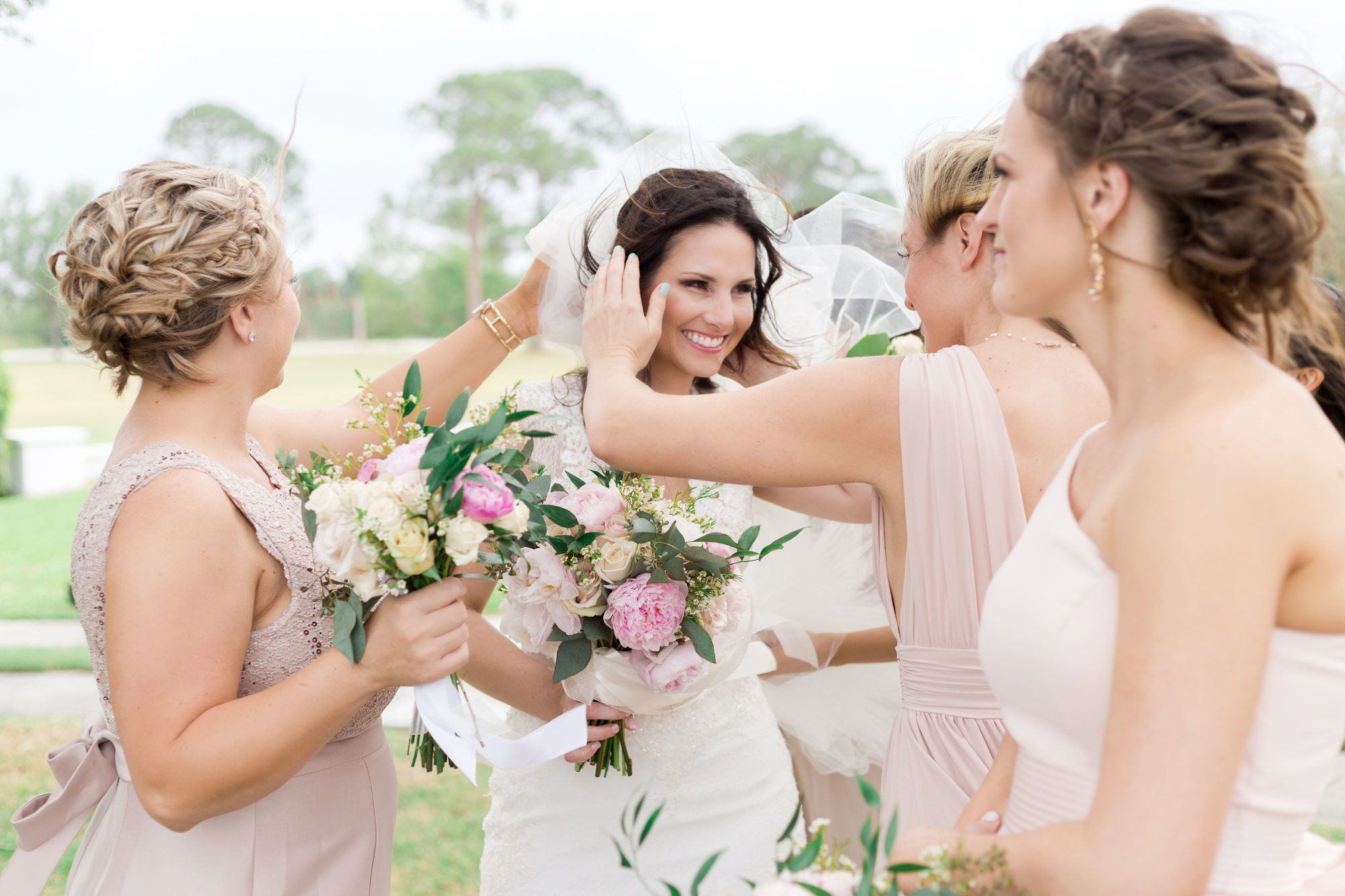 bridesmaid helping bride with her veil