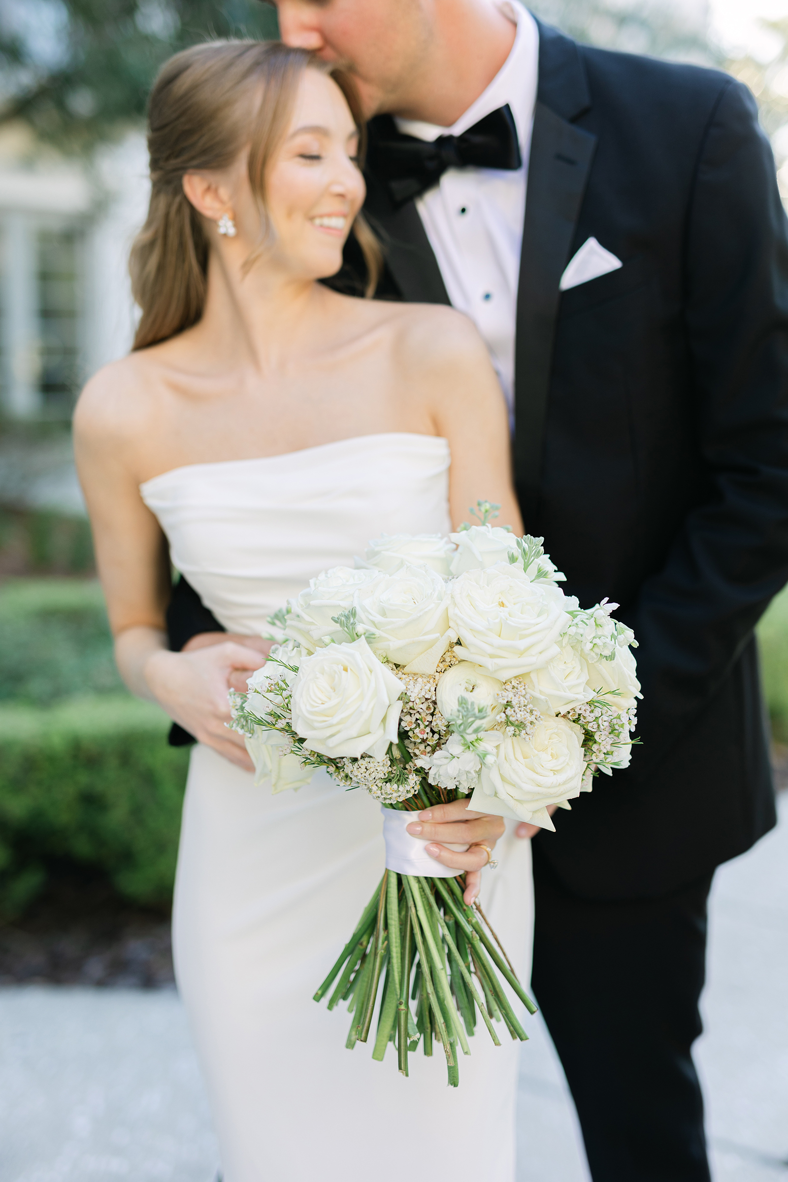 close-up of bride and groom with bouquet