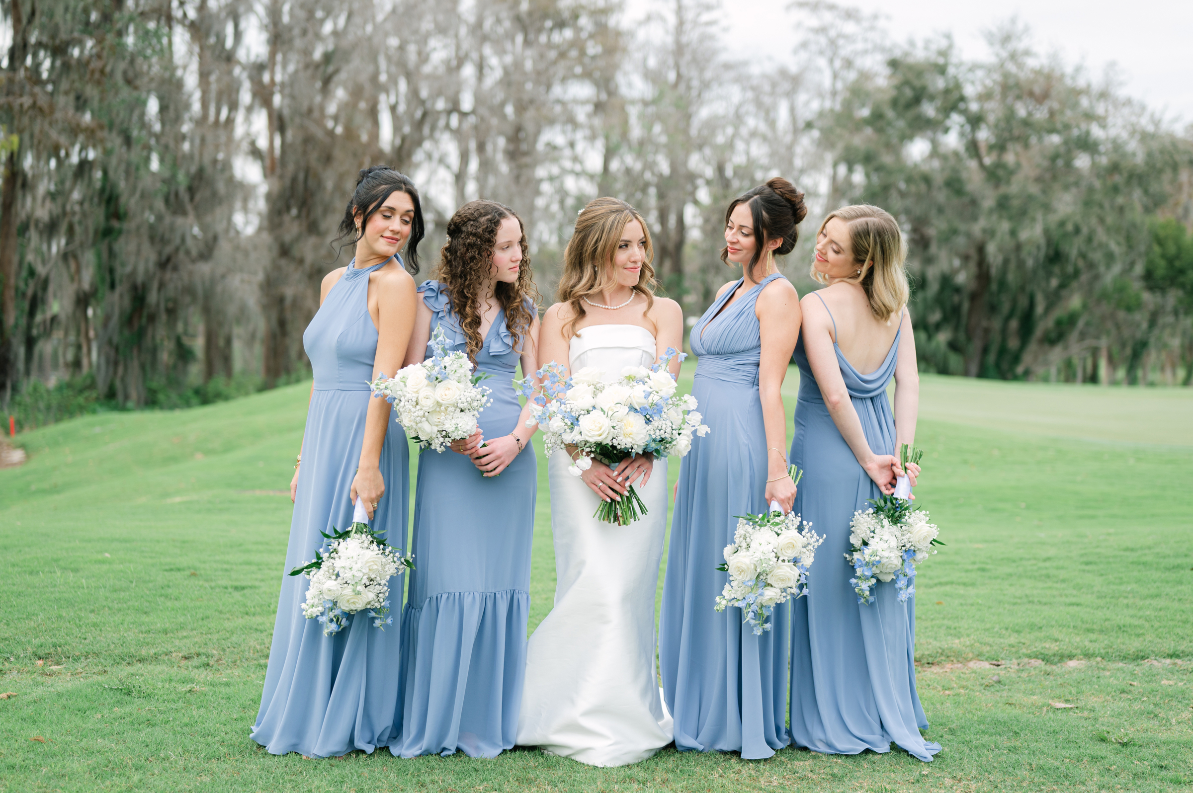 blue and white bridesmaid dresses with bouquets
