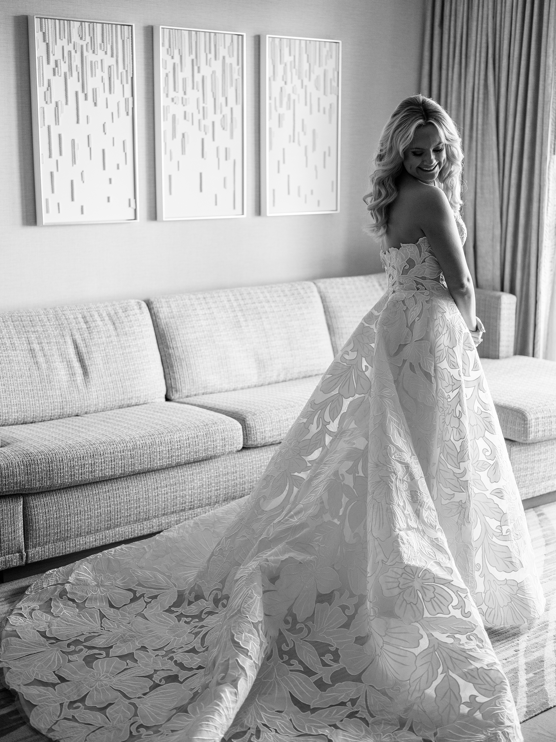 black and white picture of bride getting ready with lace wedding dress and white heels with gem detail