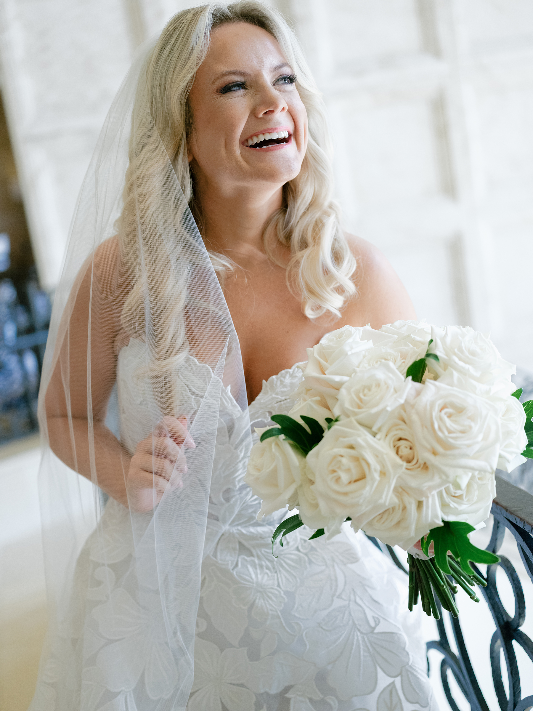 picture of bride with traditional lace wedding dress and white roses