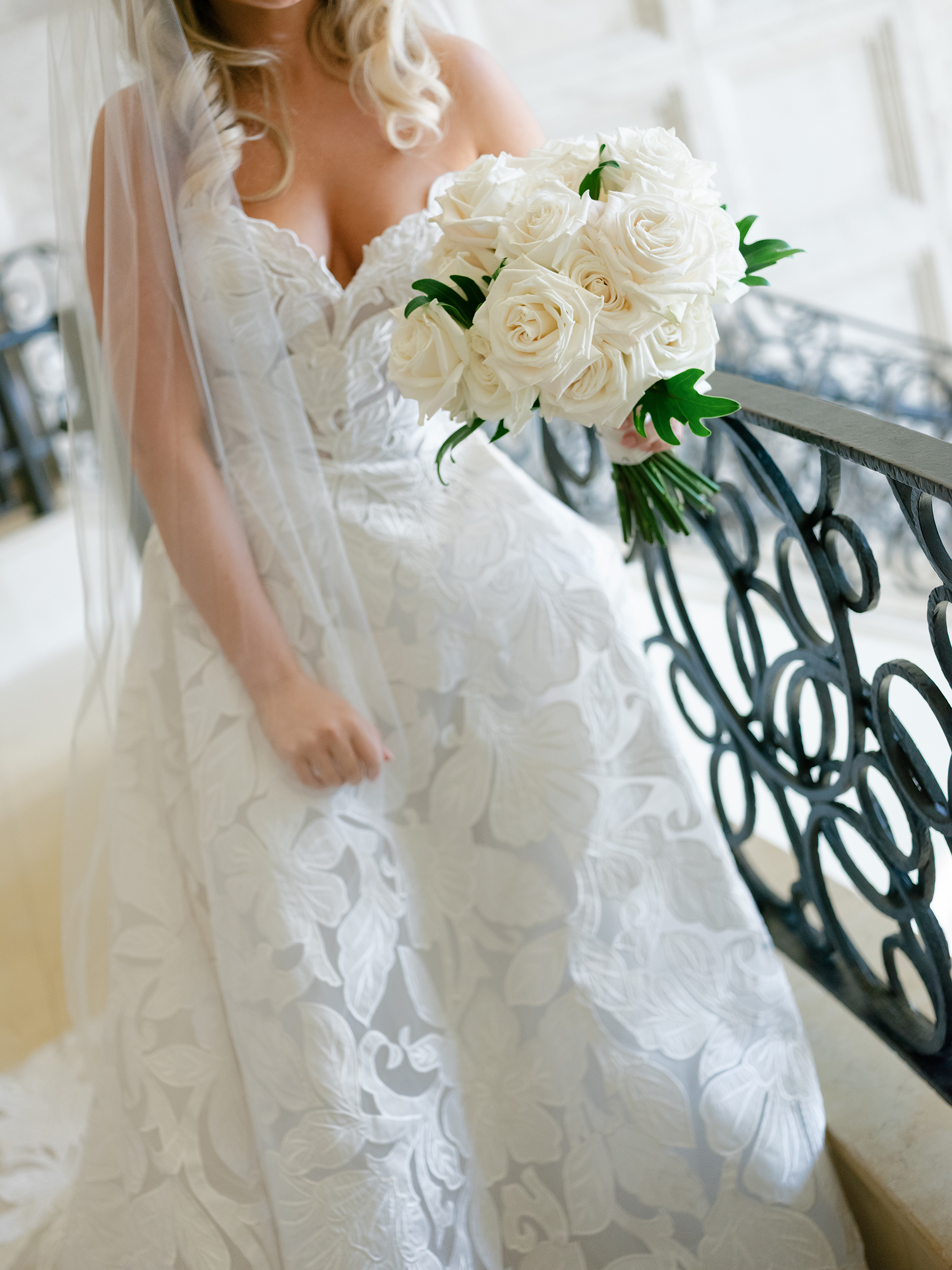 picture of bride with traditional lace wedding dress and white roses