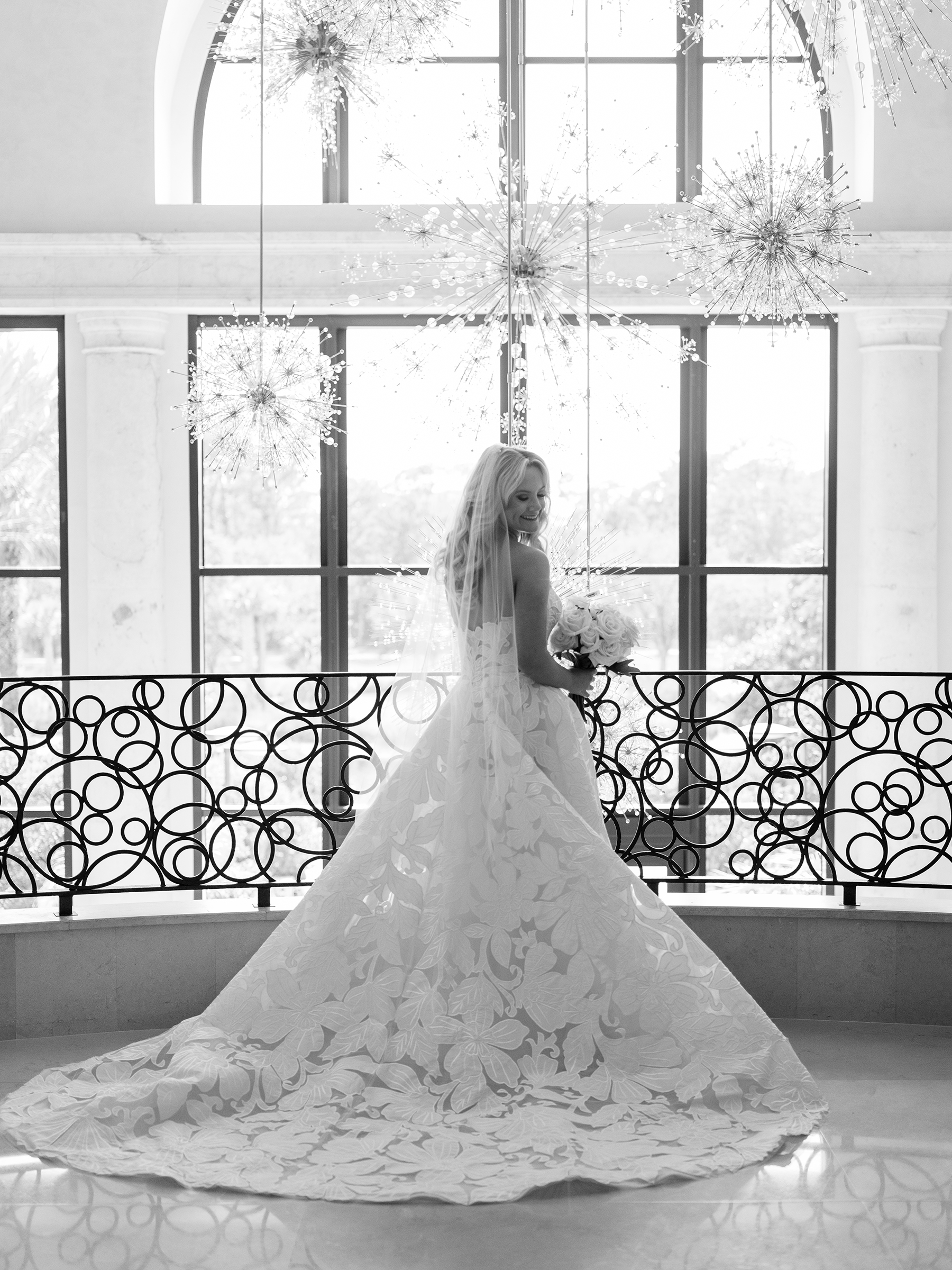 black and white picture of bride with traditional lace wedding dress and white roses