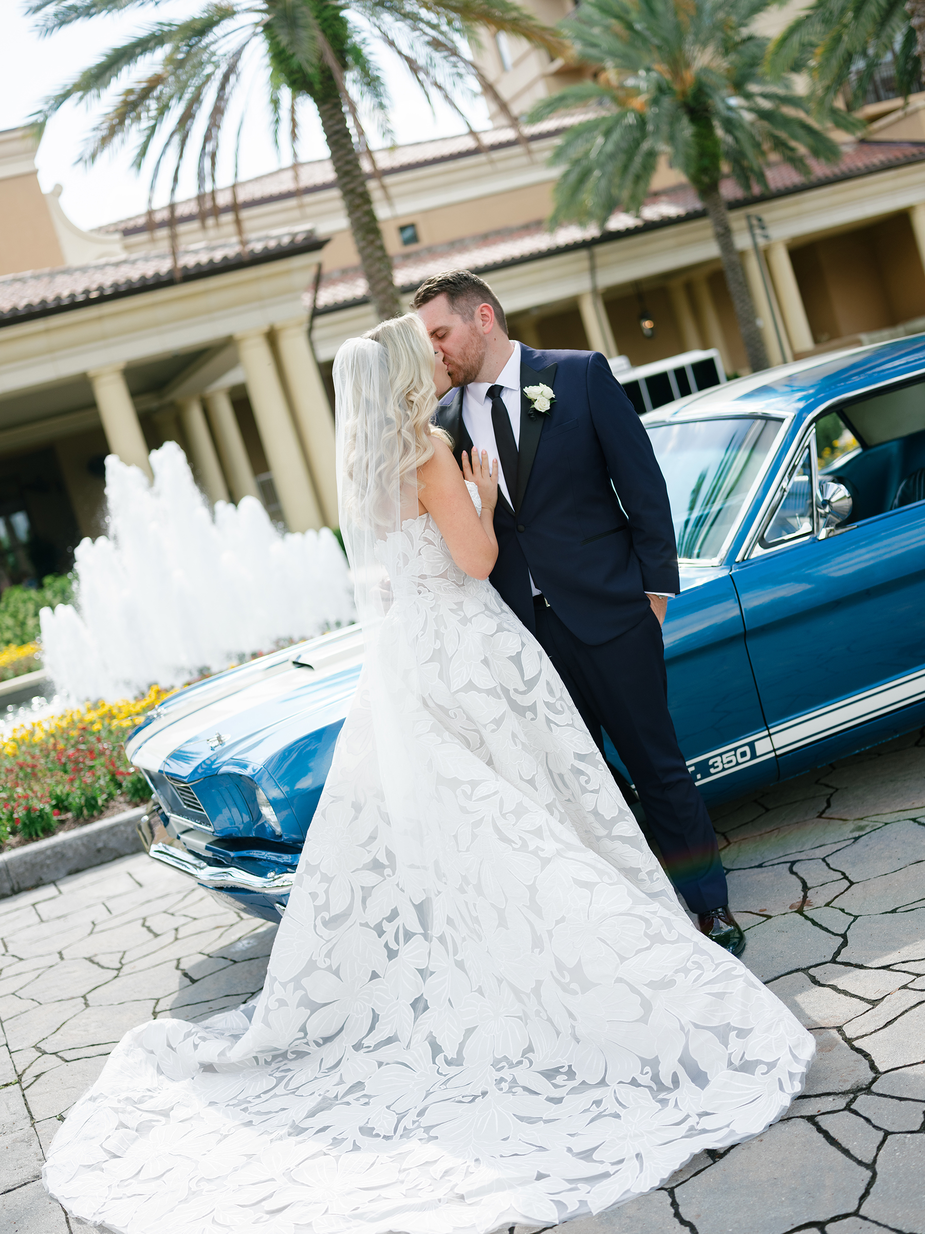bride and groom traditional wedding picture in front of vintage car