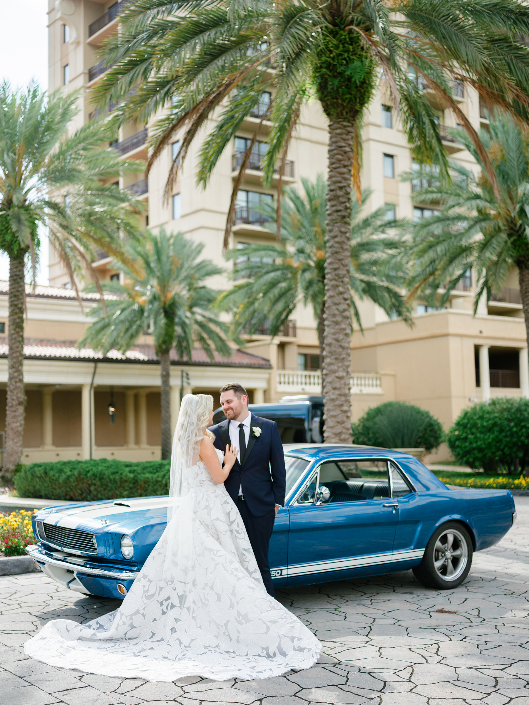 bride and groom traditional wedding picture in front of vintage car