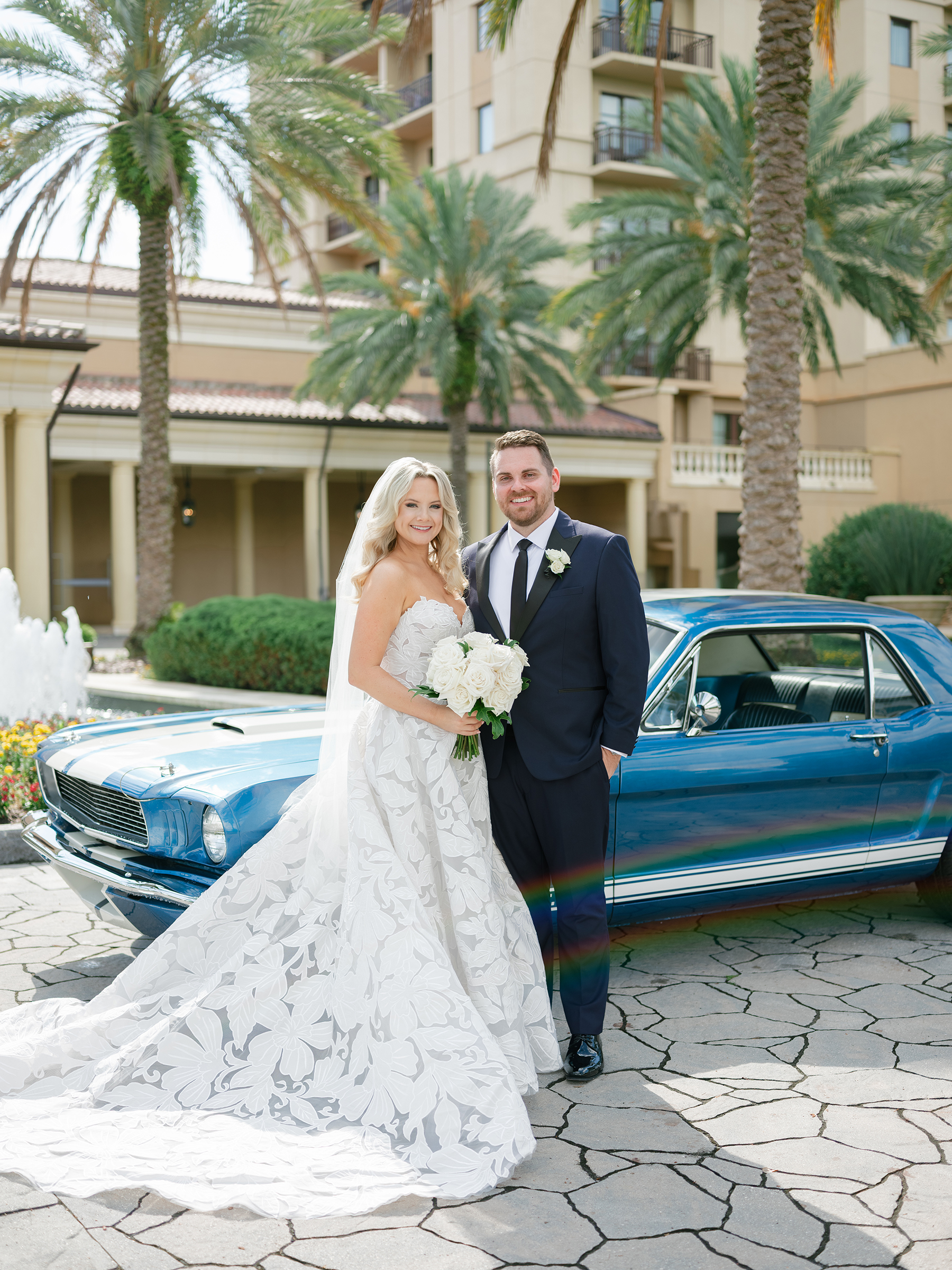 bride and groom traditional wedding picture in front of vintage car