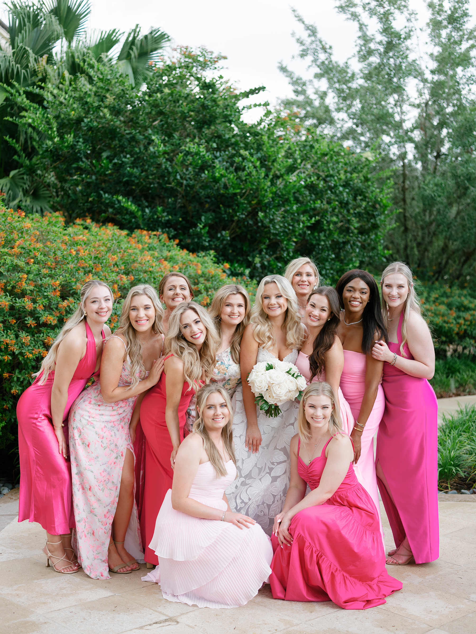 bride with bridesmaids in pink patterned colored dresses