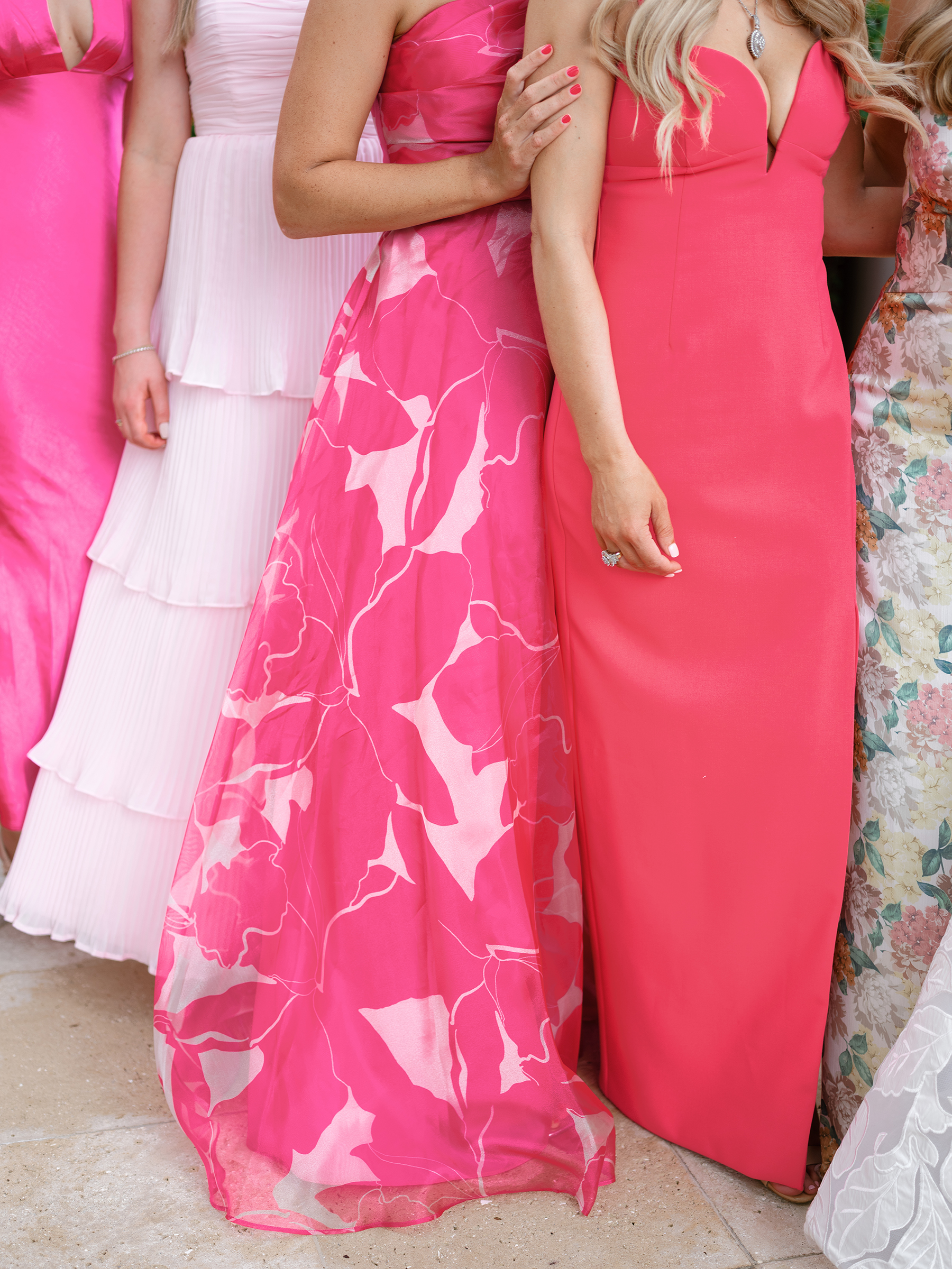 bride with bridesmaids in pink patterned colored dresses