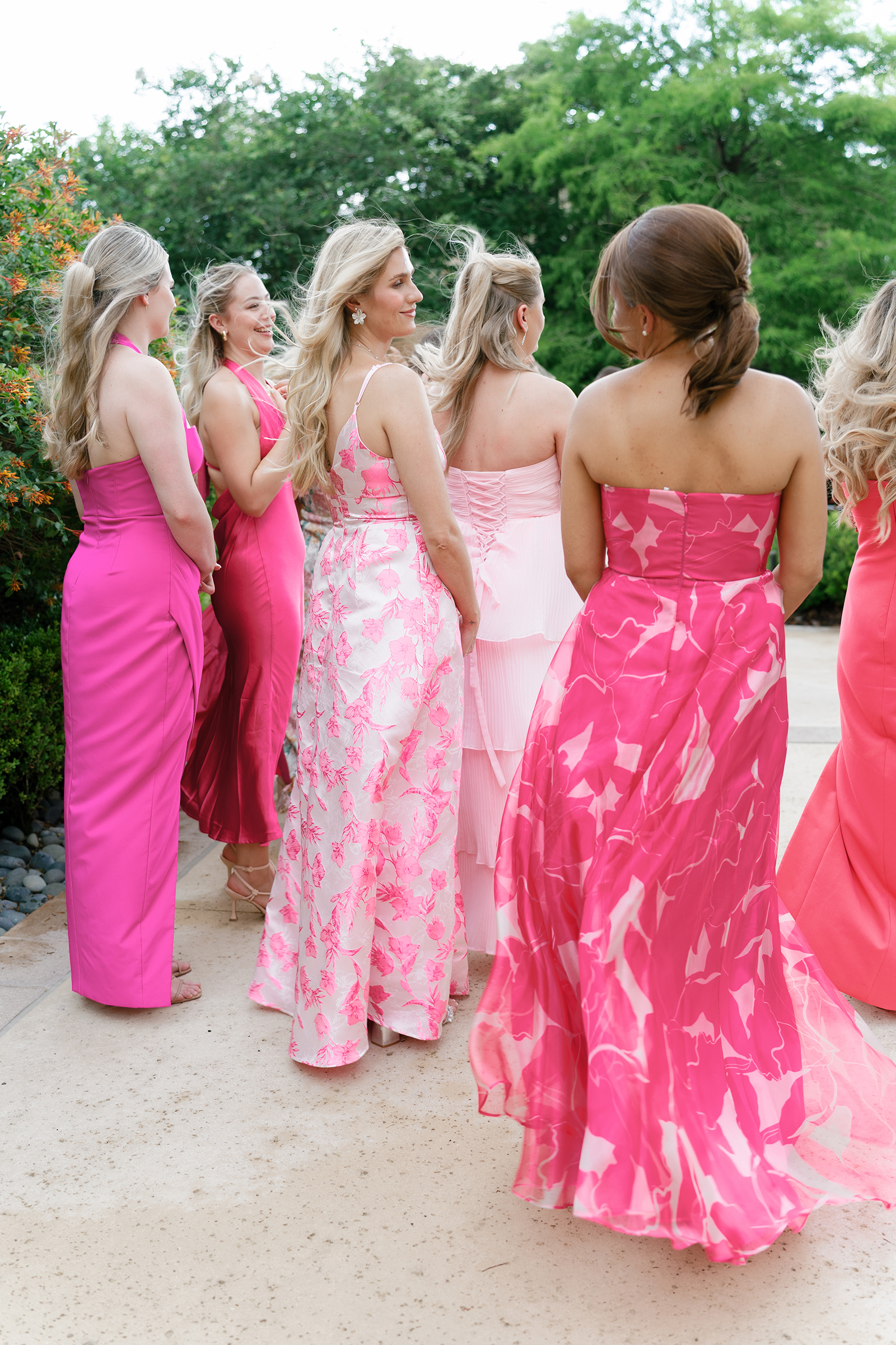 bride with bridesmaids in pink patterned colored dresses