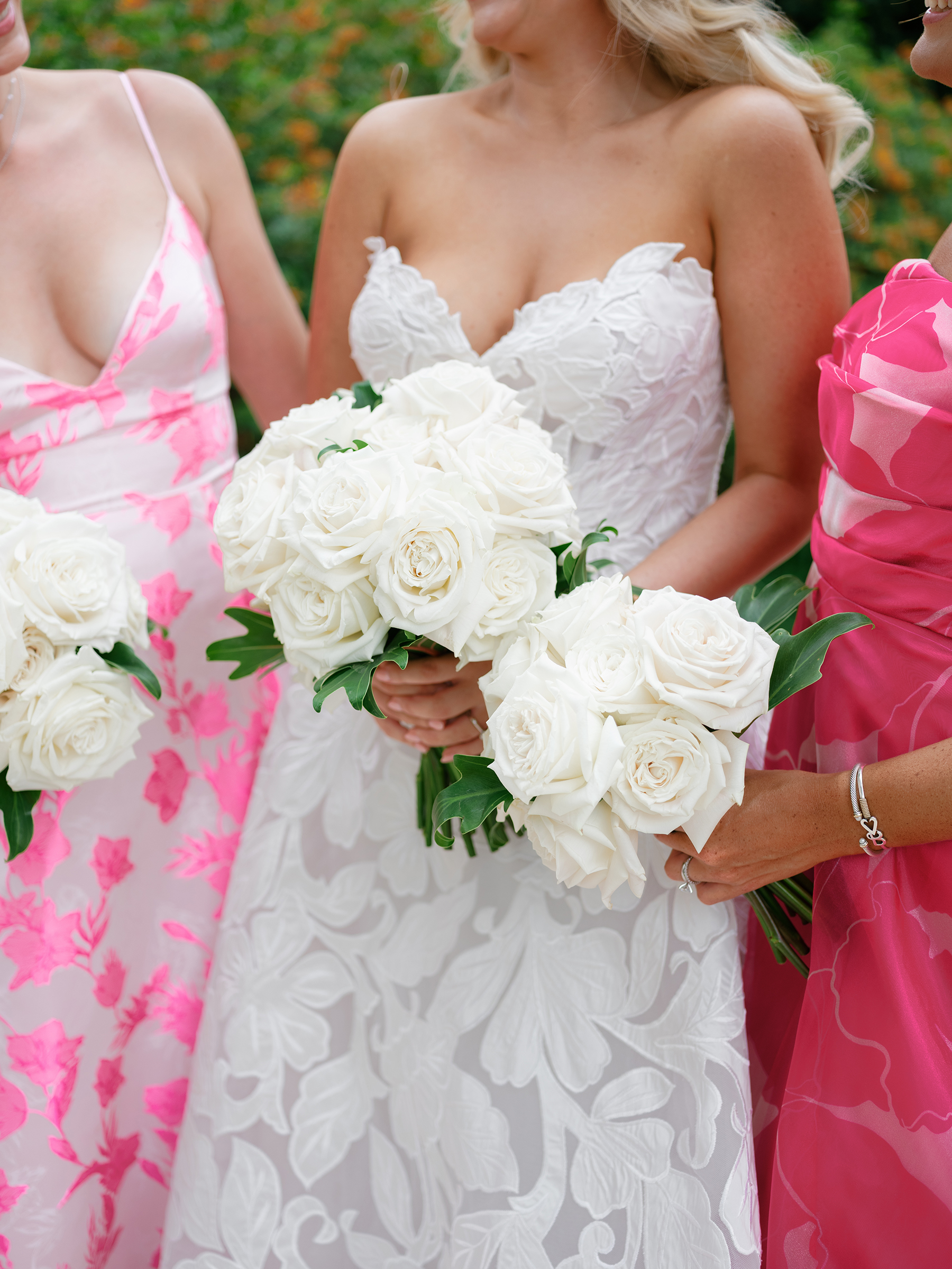 bride with bridesmaids in pink patterned colored dresses