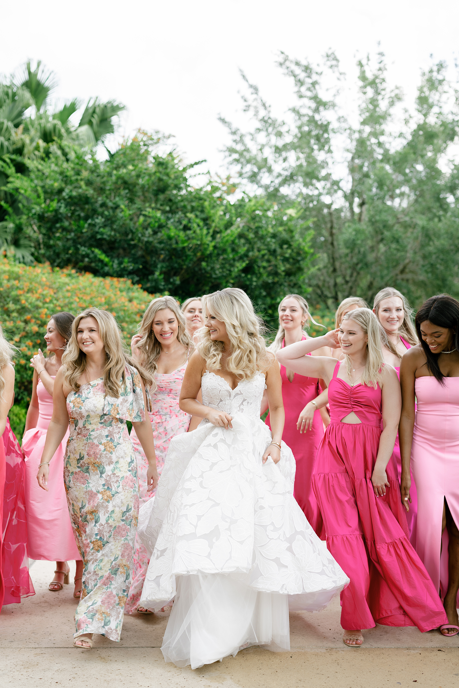 bride with bridesmaids in pink patterned colored dresses