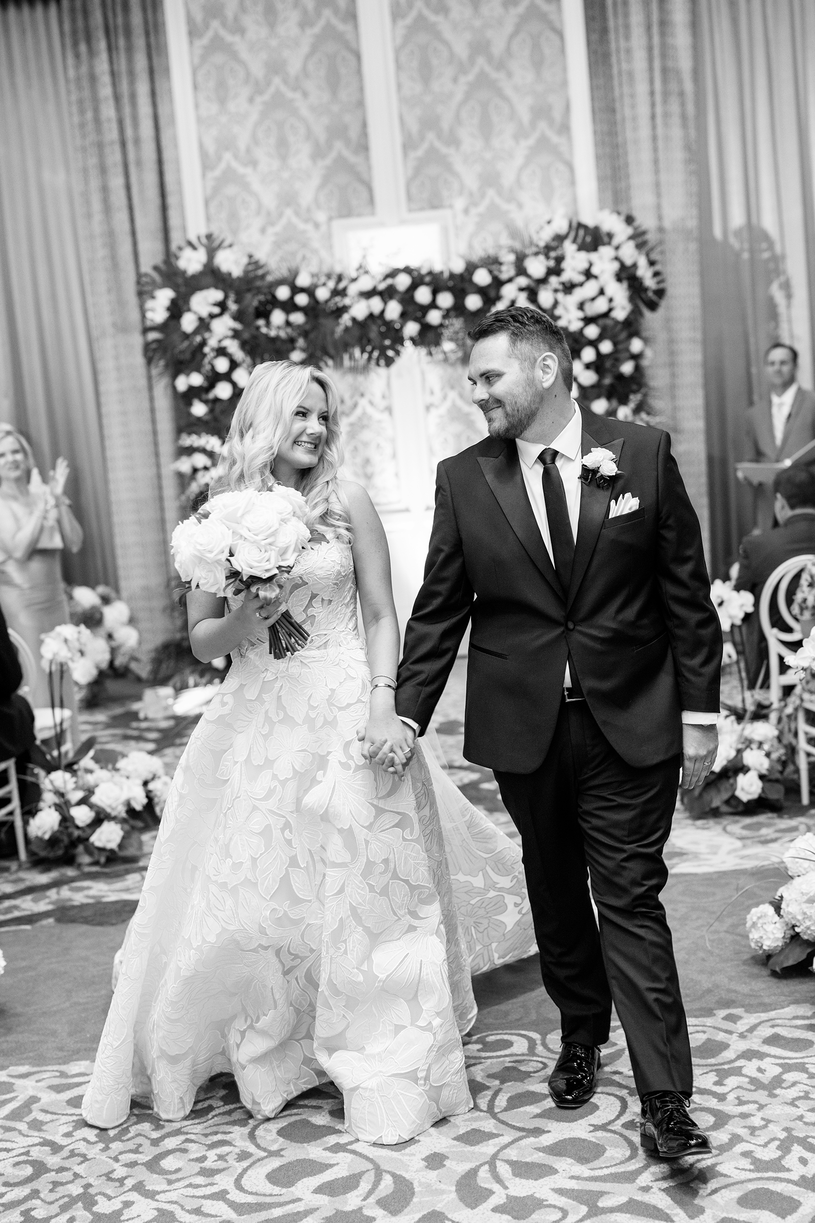 black and white picture of bride walking down the aisle