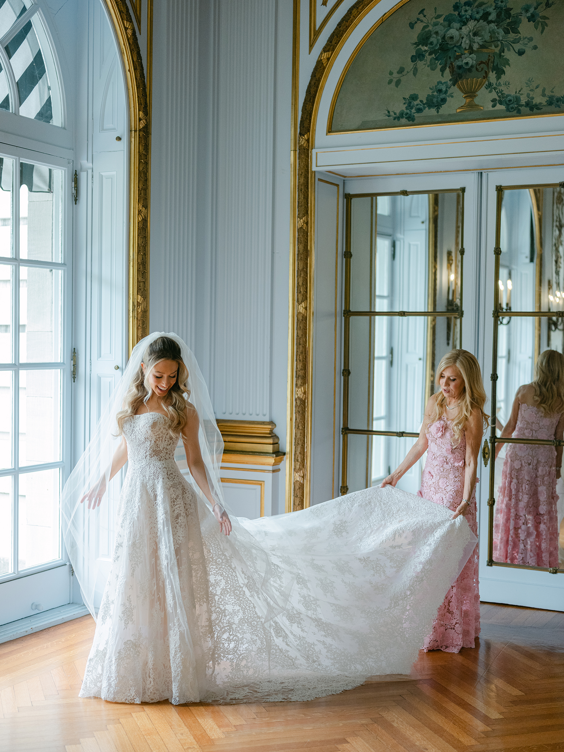 mom helping hold bride's dress 