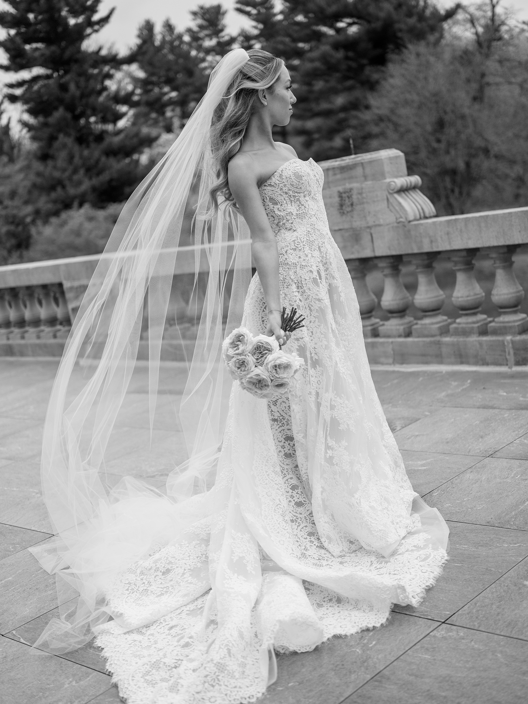 bride wearing white lace wedding dress holding pink bouquet