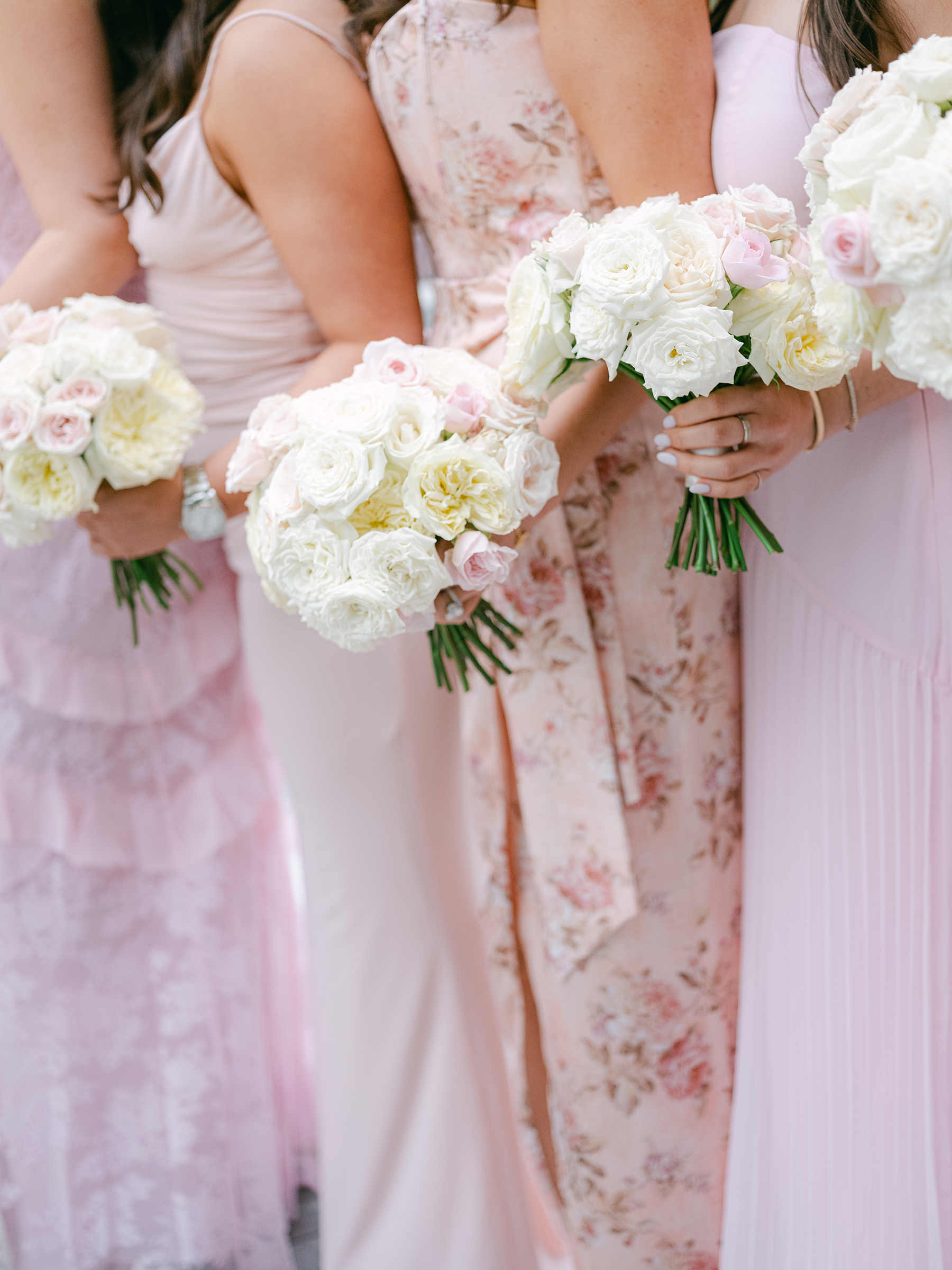 blush and baby pink bridesmaid dresses holding pink and white bouquets