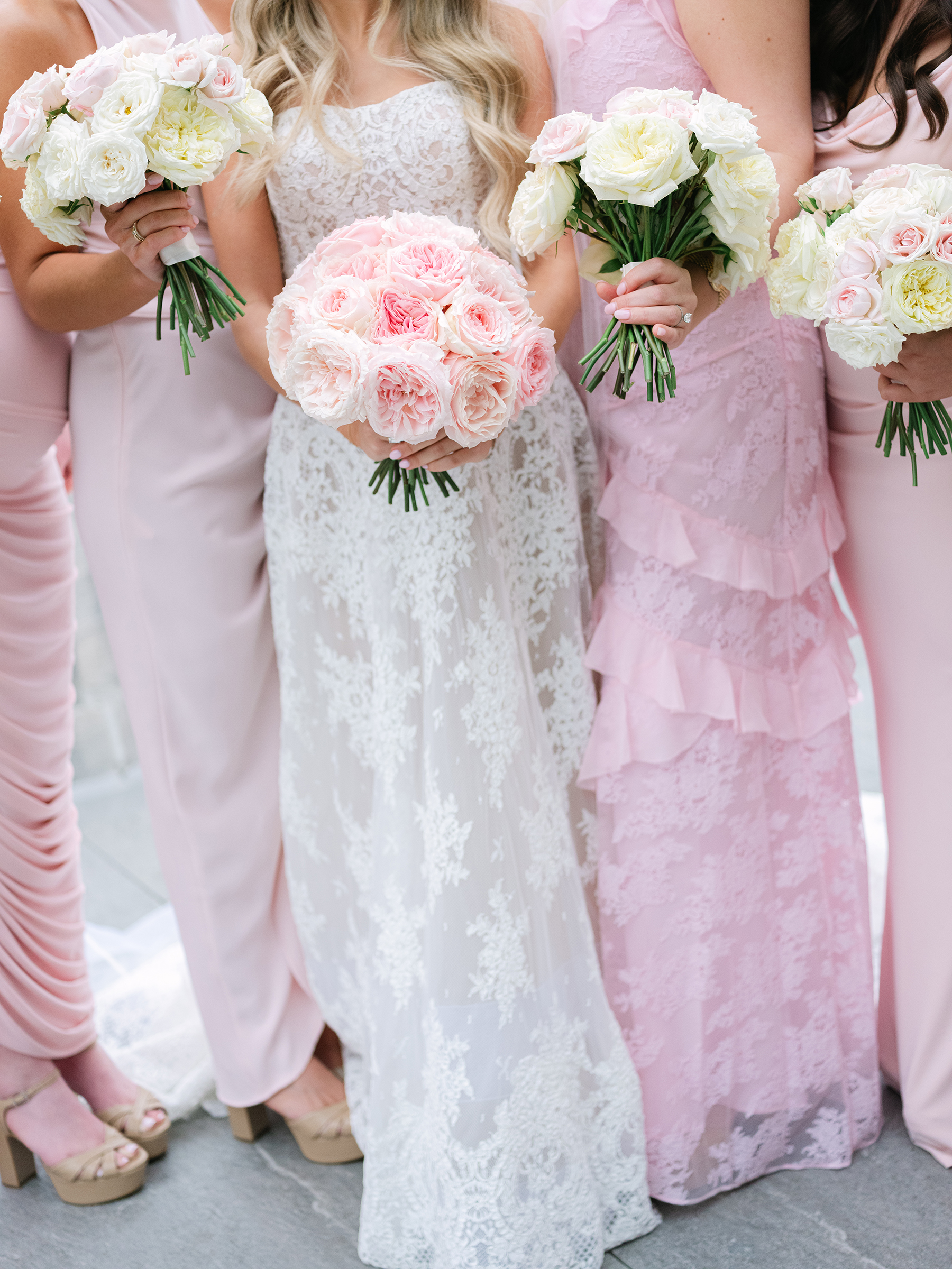 blush and baby pink bridesmaid dresses holding pink and white bouquets