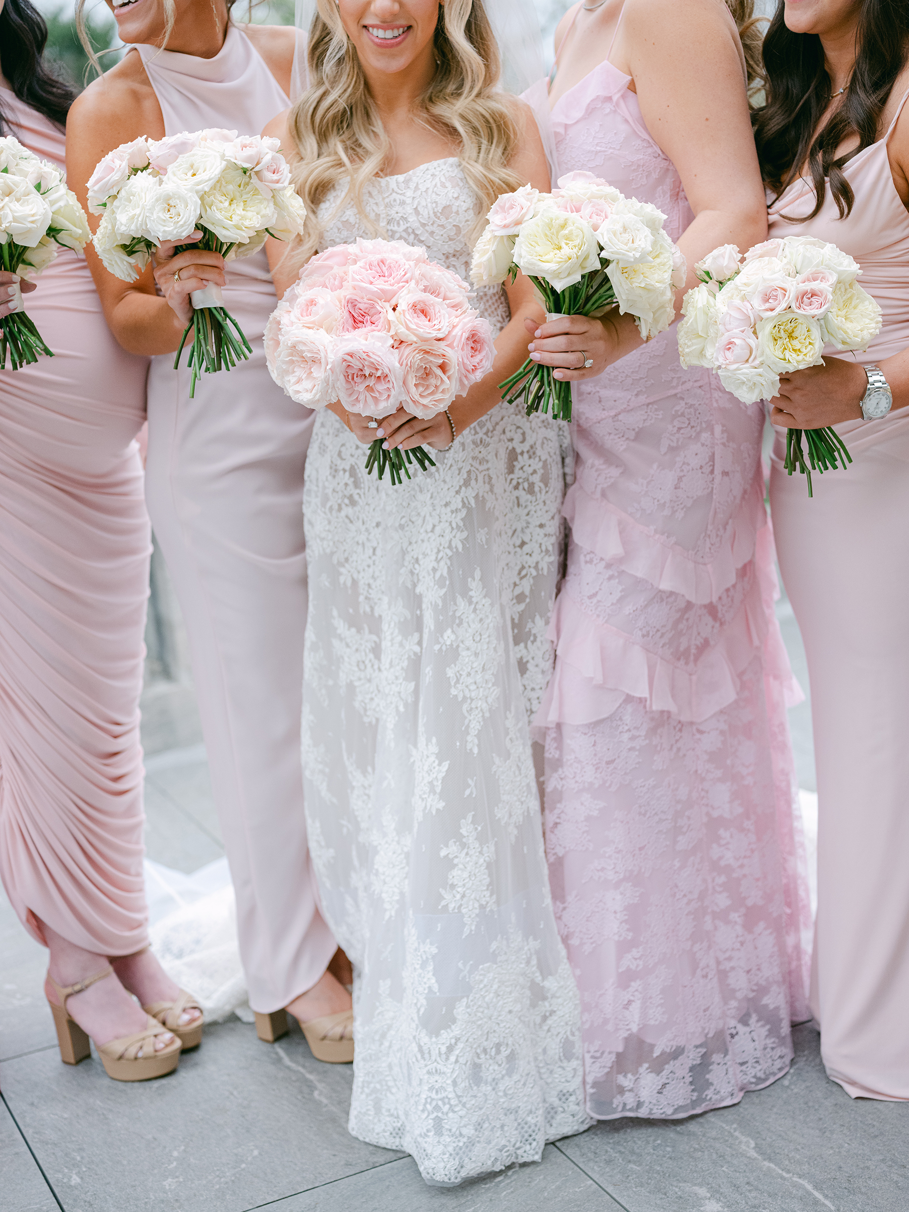 blush and baby pink bridesmaid dresses holding pink and white bouquets