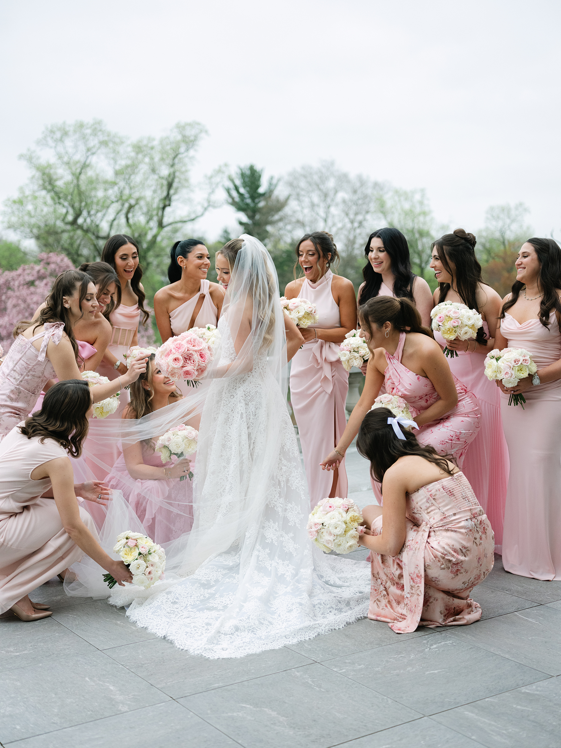 bride with bridesmaids dressed in mismatched blush and light pink dresses 
