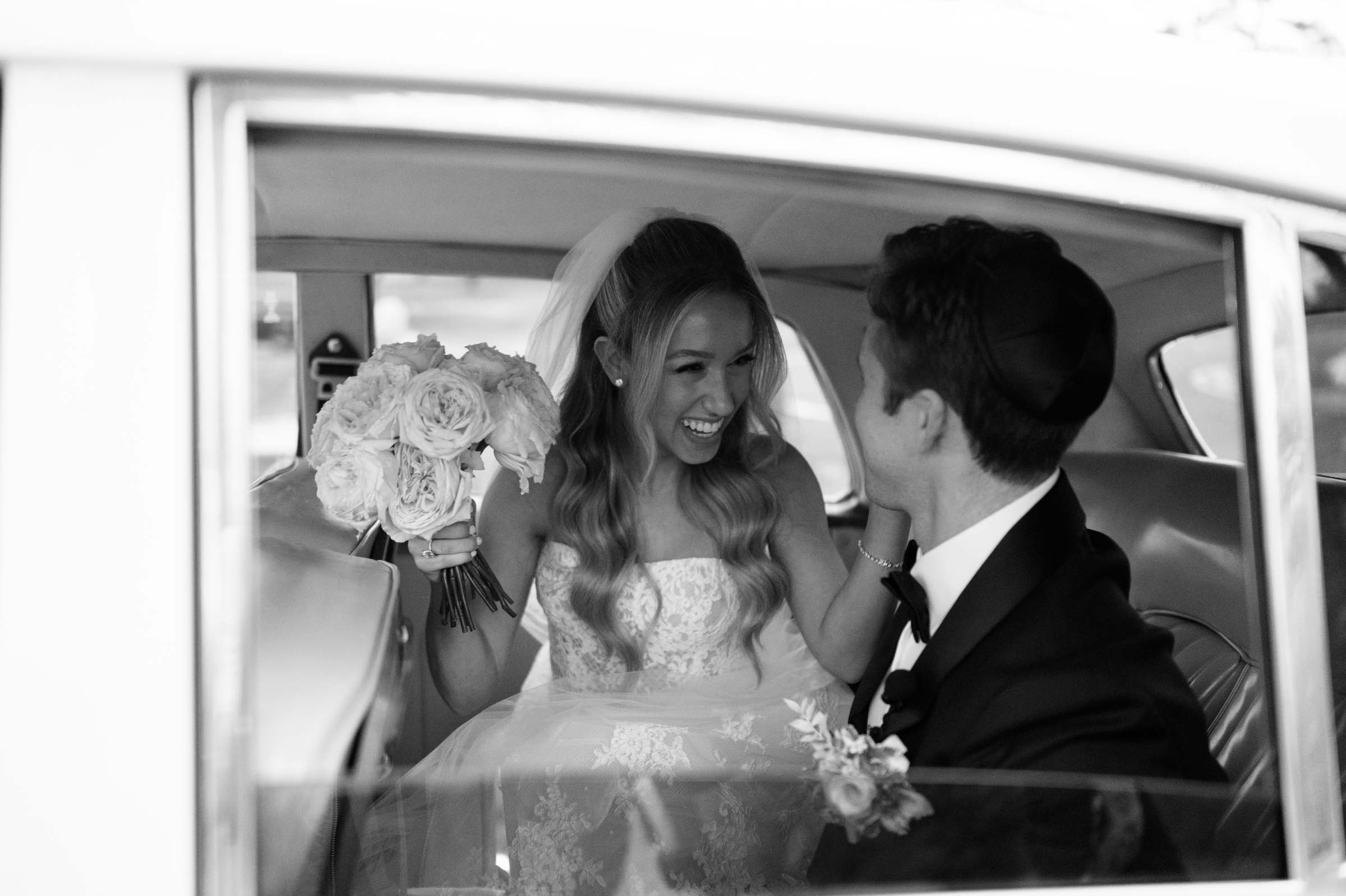 bride and groom in luxury/classic wedding car