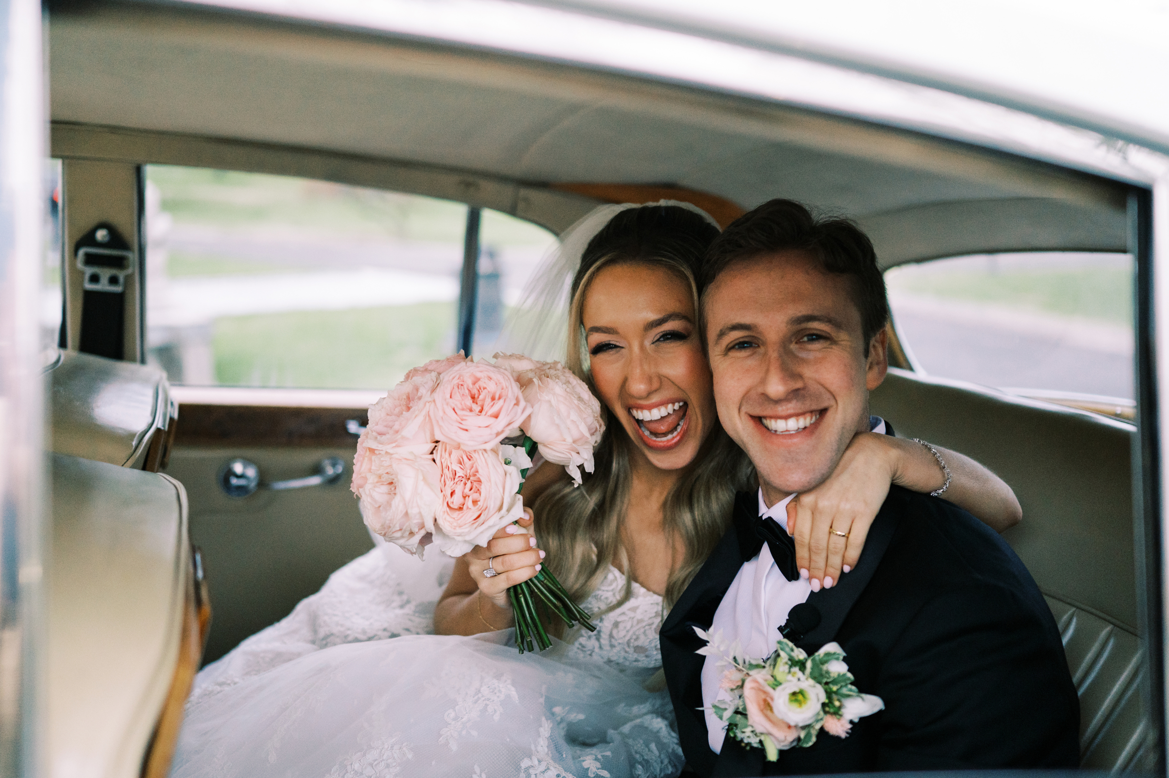 bride and groom in luxury/classic wedding car