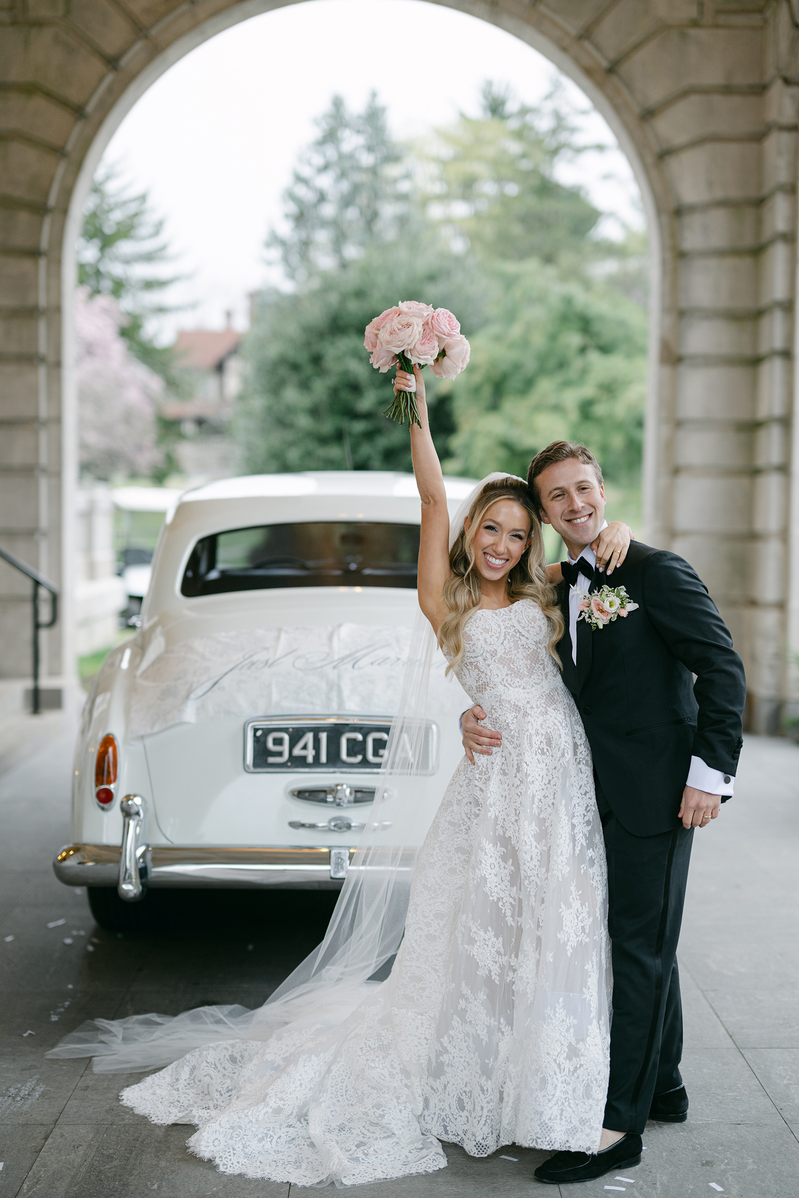 bride and groom in front of luxury/classic wedding car