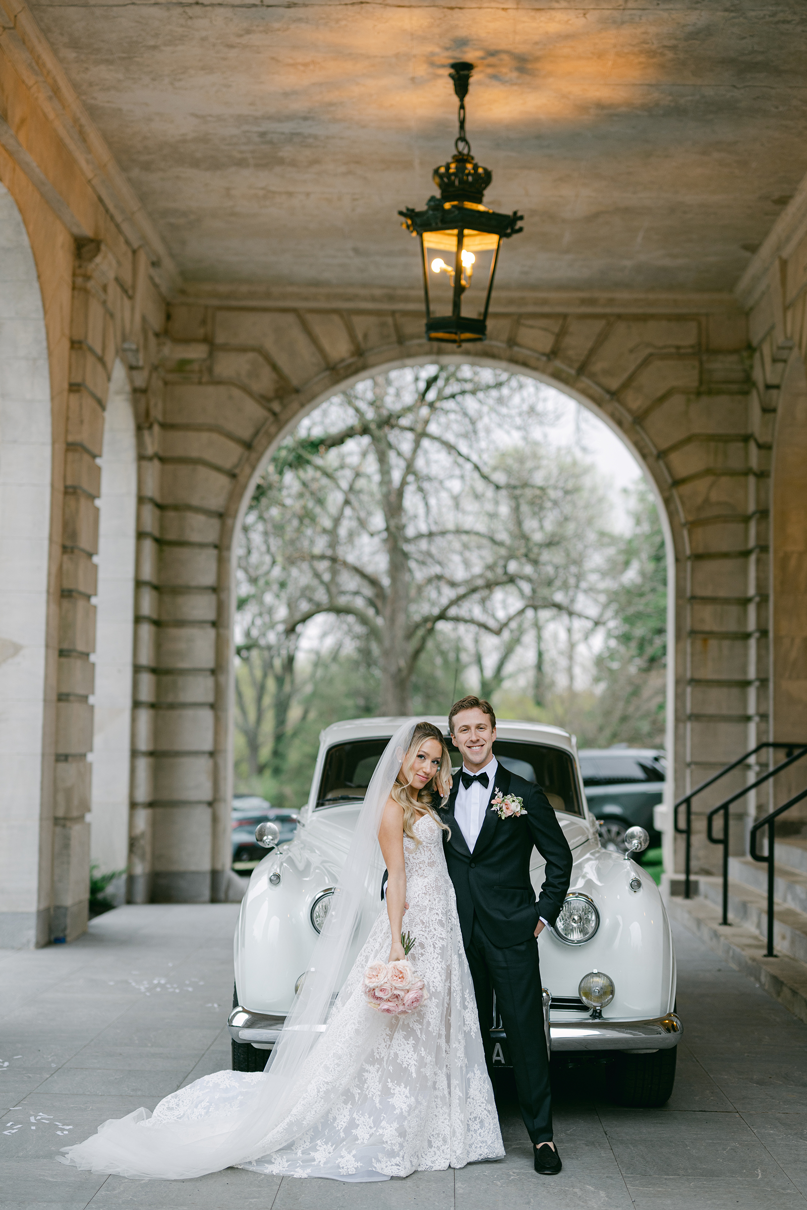 bride and groom in front of luxury/classic wedding car