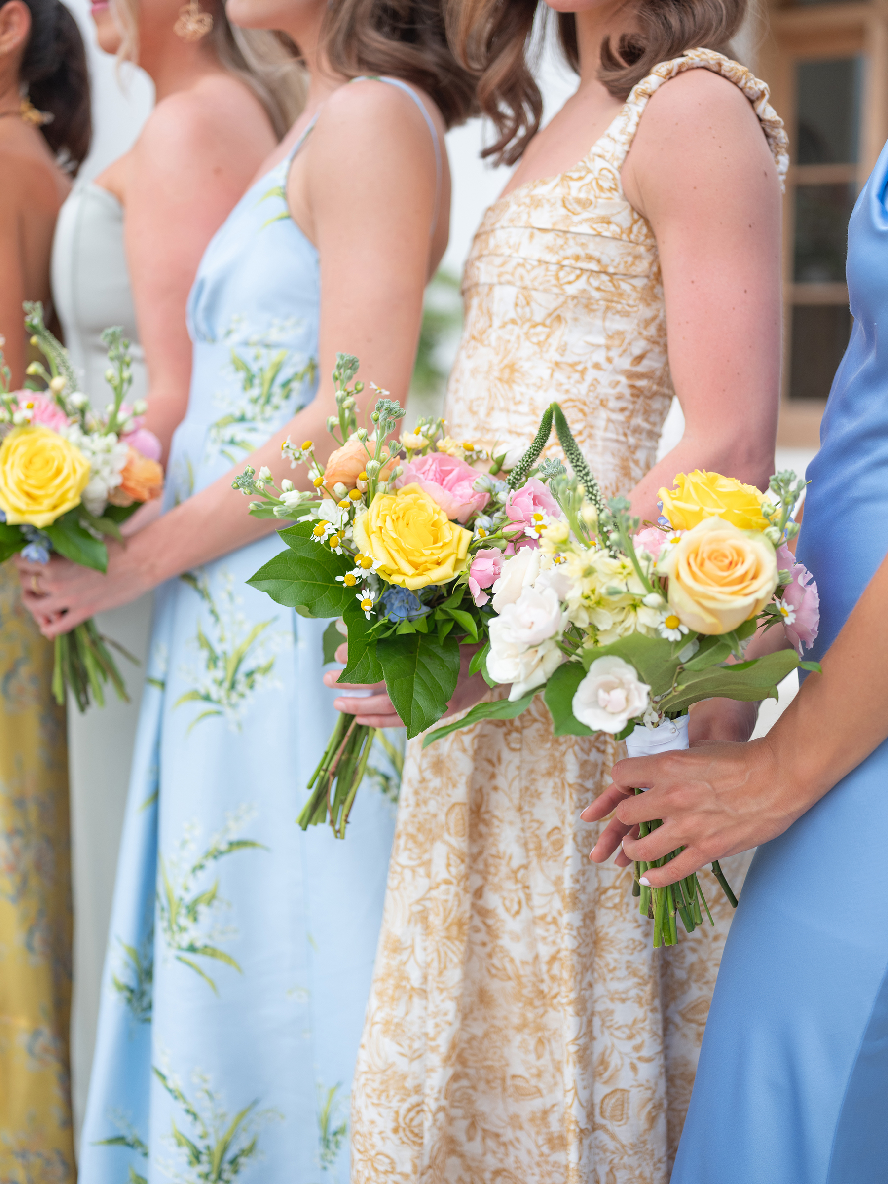 blue and beige bridesmaids' dresses with colorful bouquets