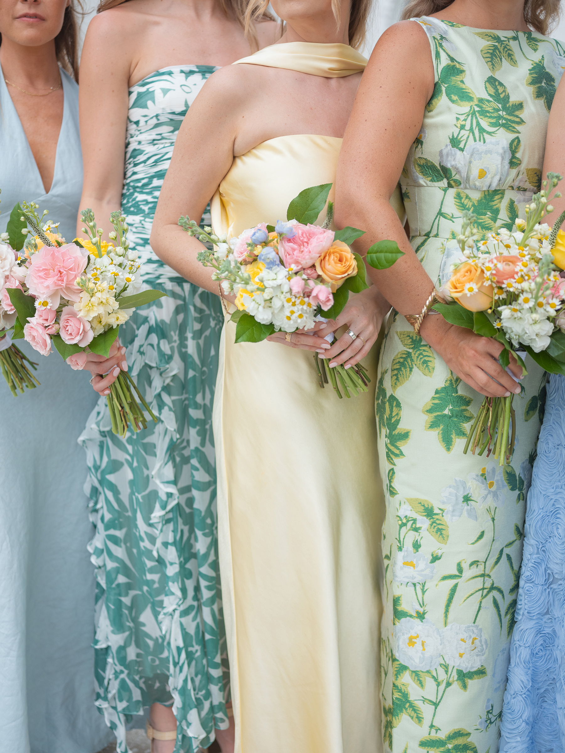 blue, green, yellow bridesmaids' dresses with colorful bouquets