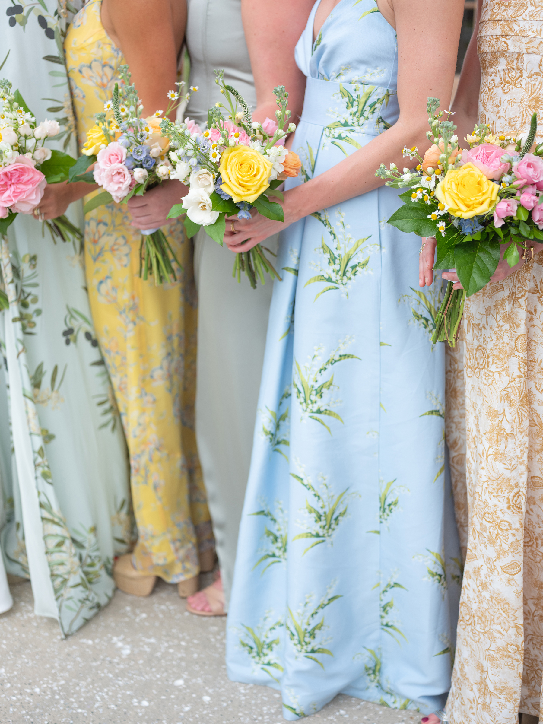 blue, green, yellow bridesmaids' dresses with colorful bouquets