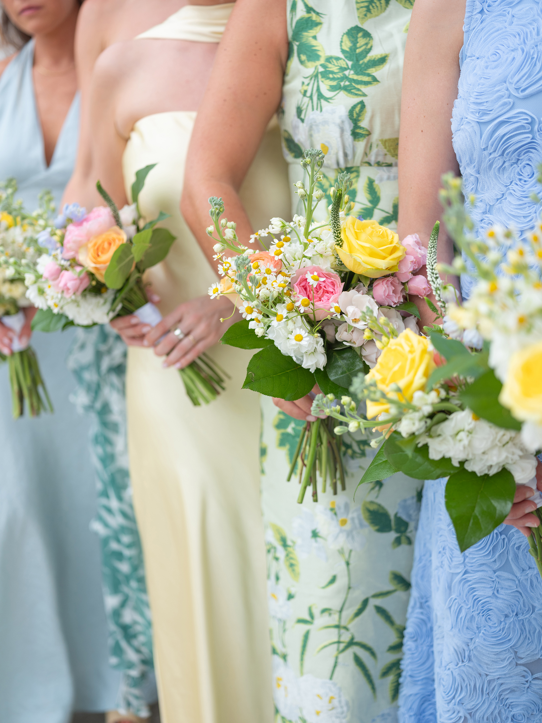 blue, green, yellow bridesmaids' dresses with colorful bouquets