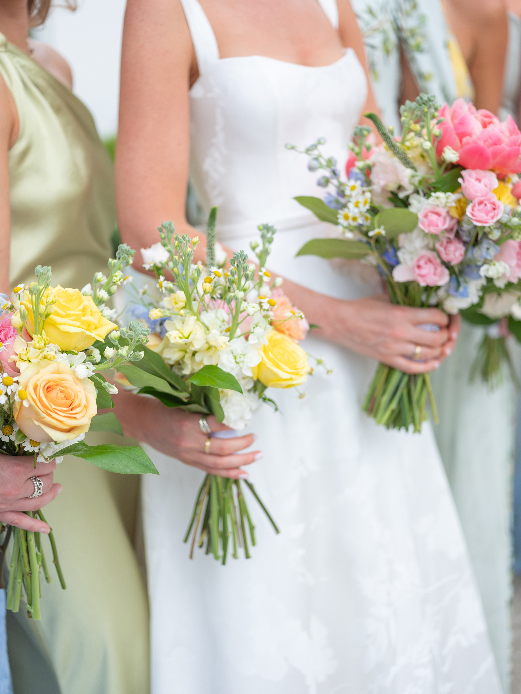 blue, green, yellow bridesmaids' dresses with colorful bouquets