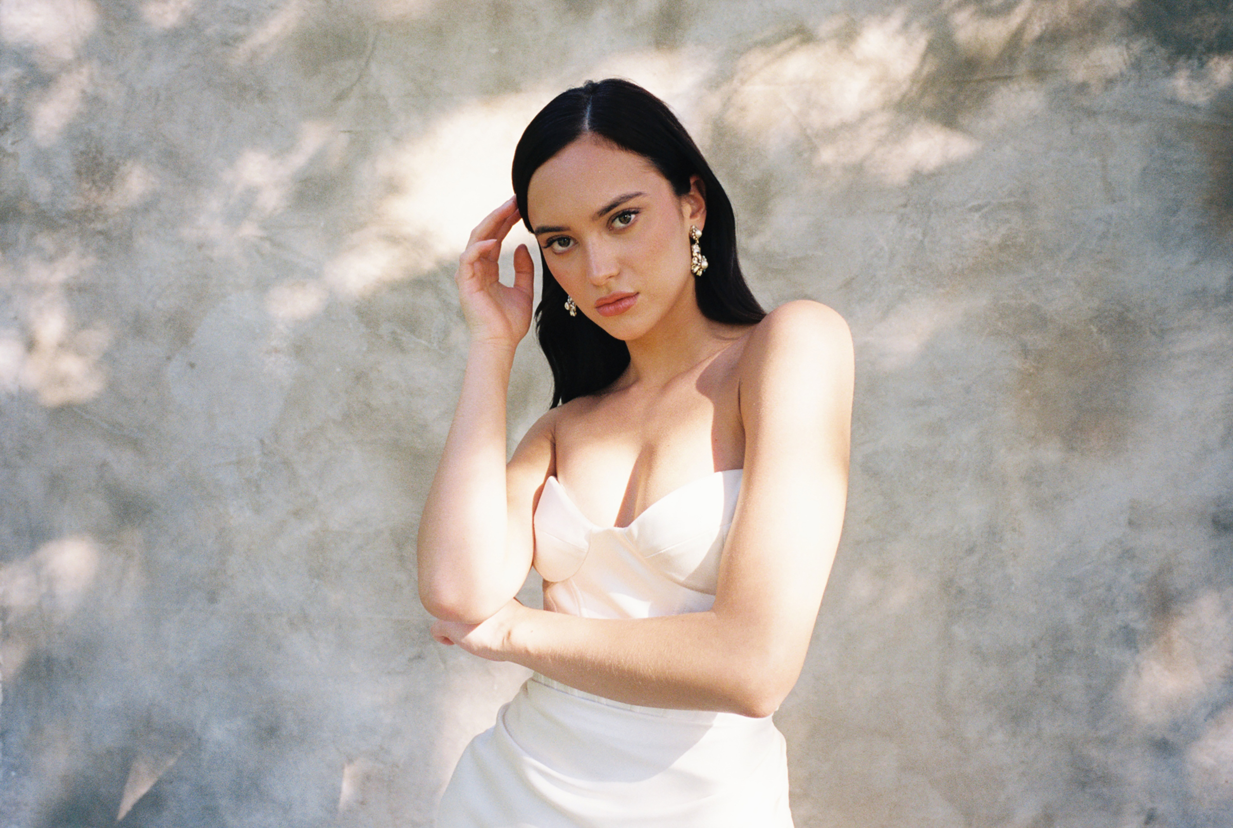 film bridal portrait of woman with corset wedding dress in front of beige canvas
