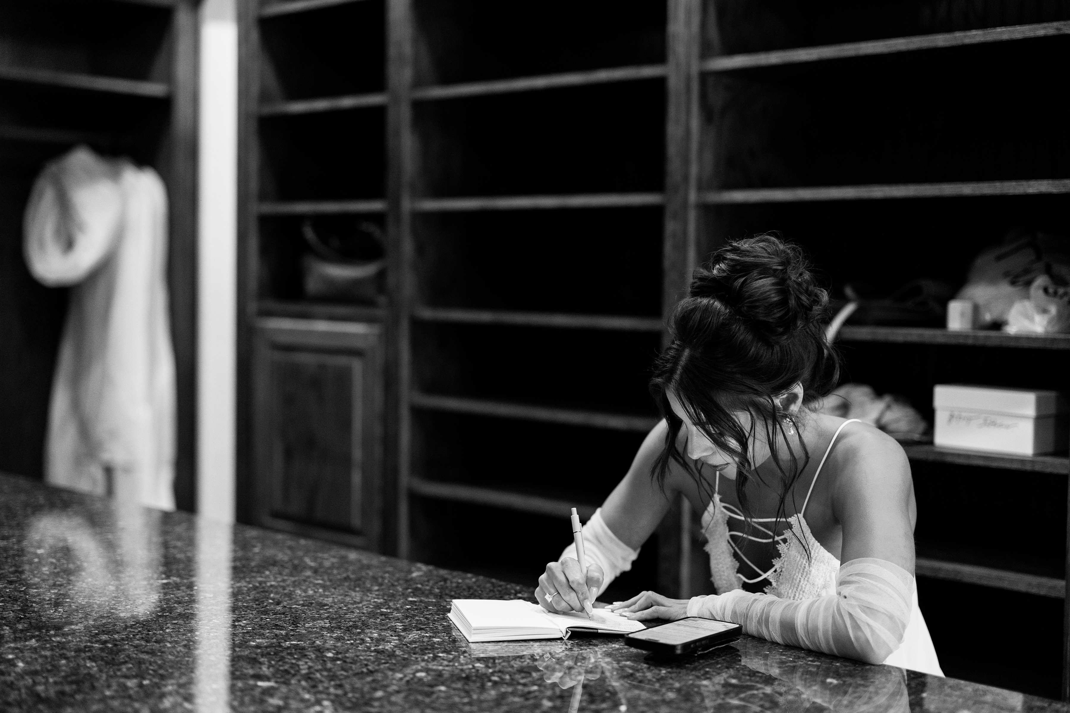 black and white picture of bride writing down vows