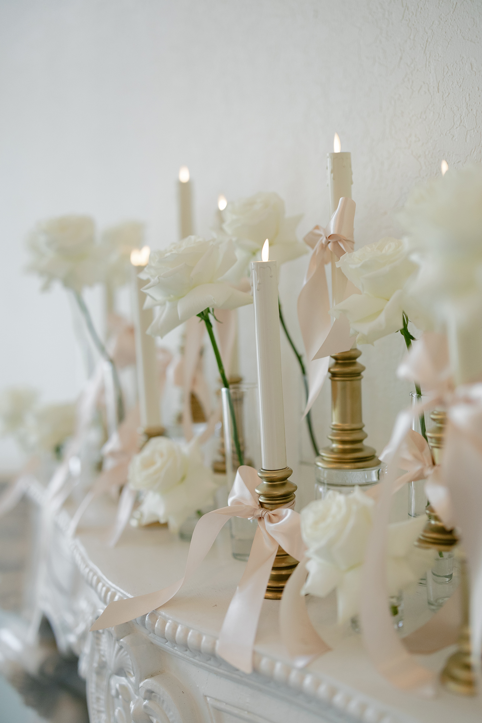 white roses and candles with ribbons for wedding ceremony