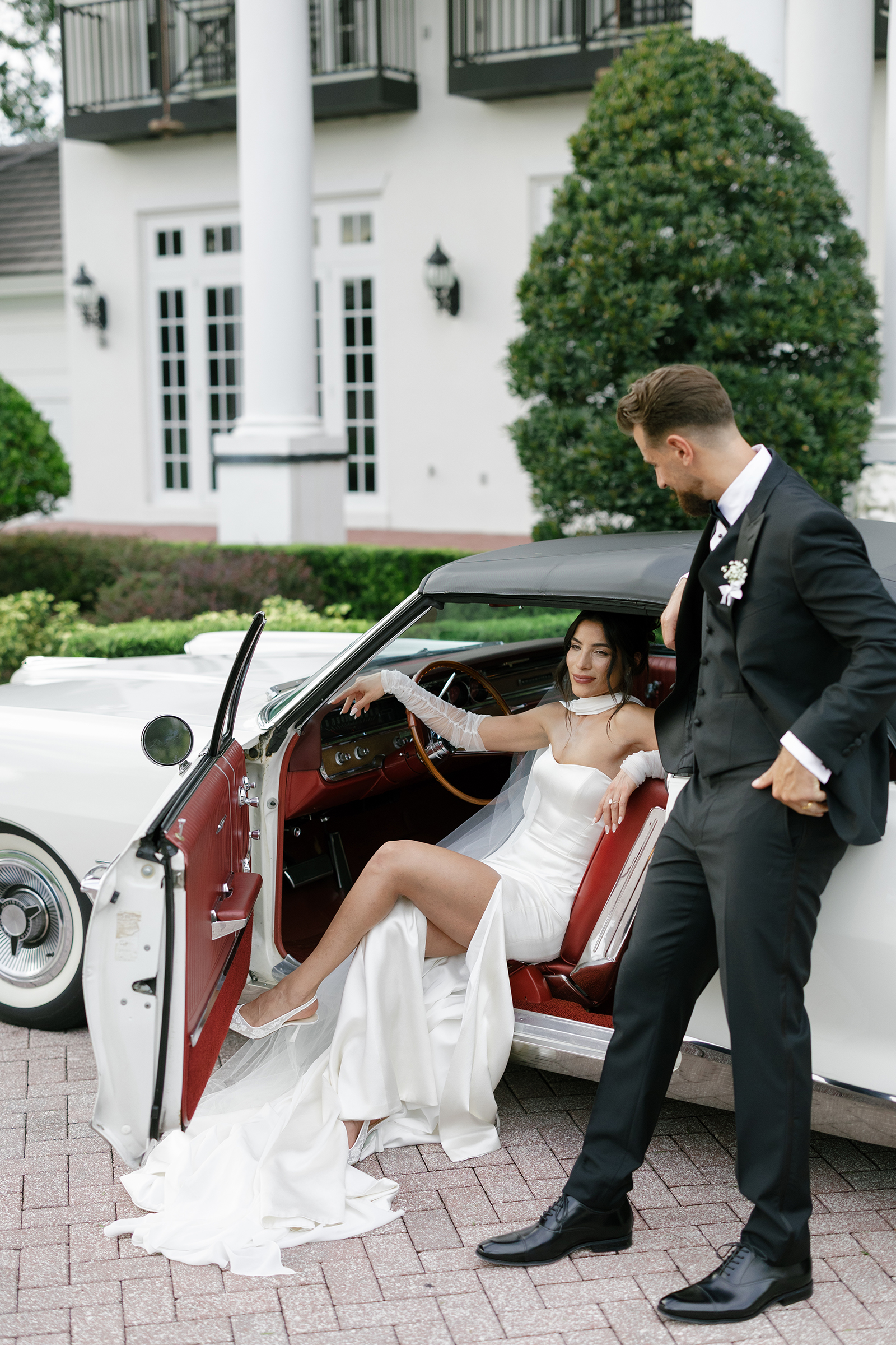 picture of bride and groom in front of luxury car