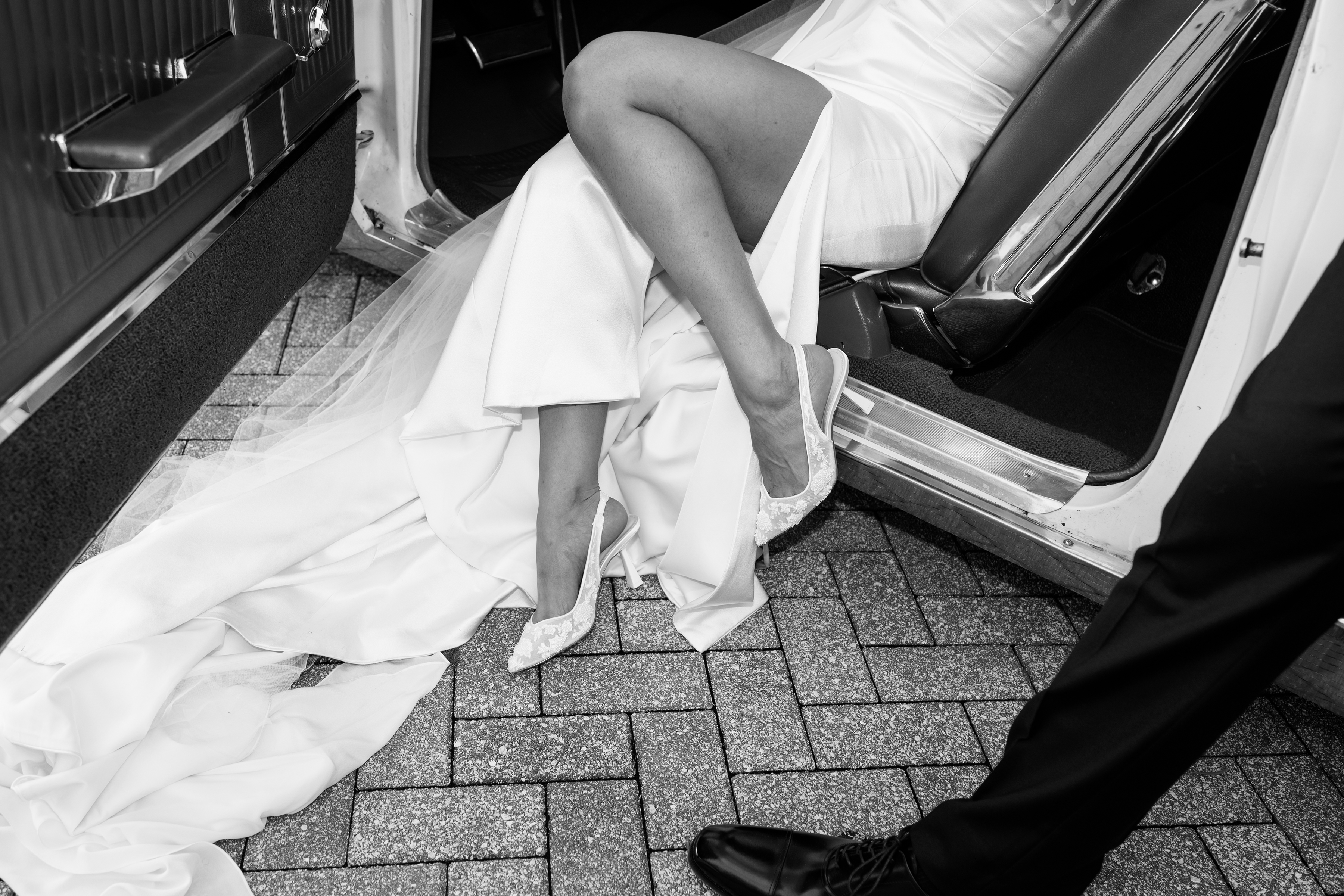 black and white close-up picture of heels and wedding dress