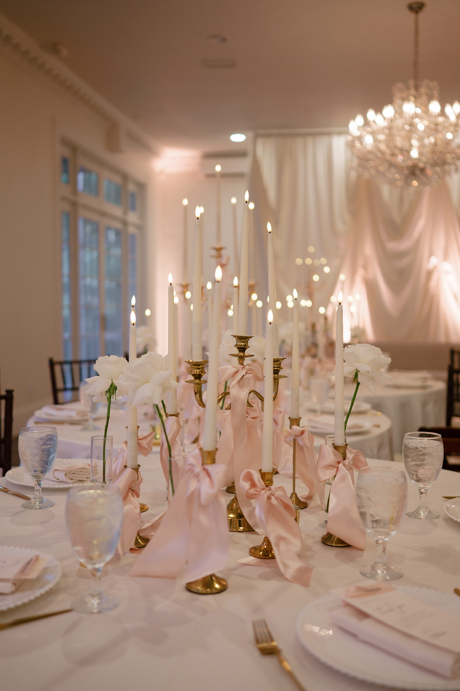 pink and white reception decor with candles on table