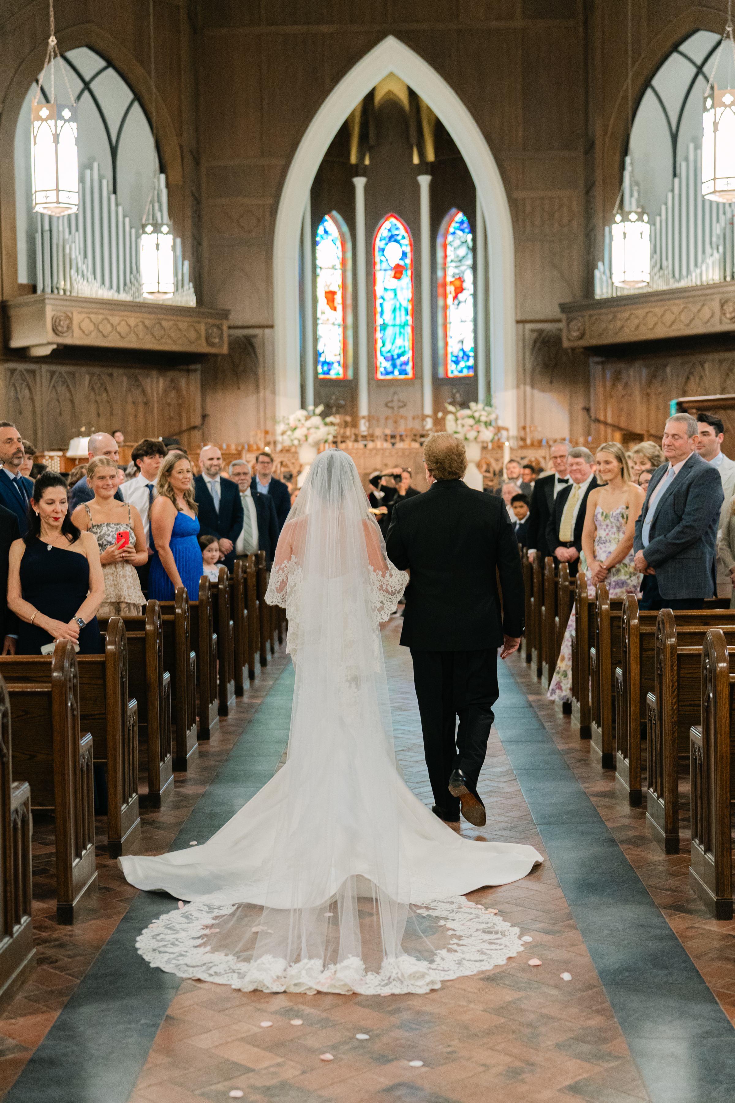father walks the bride down the aisle at chapel wedding ceremony