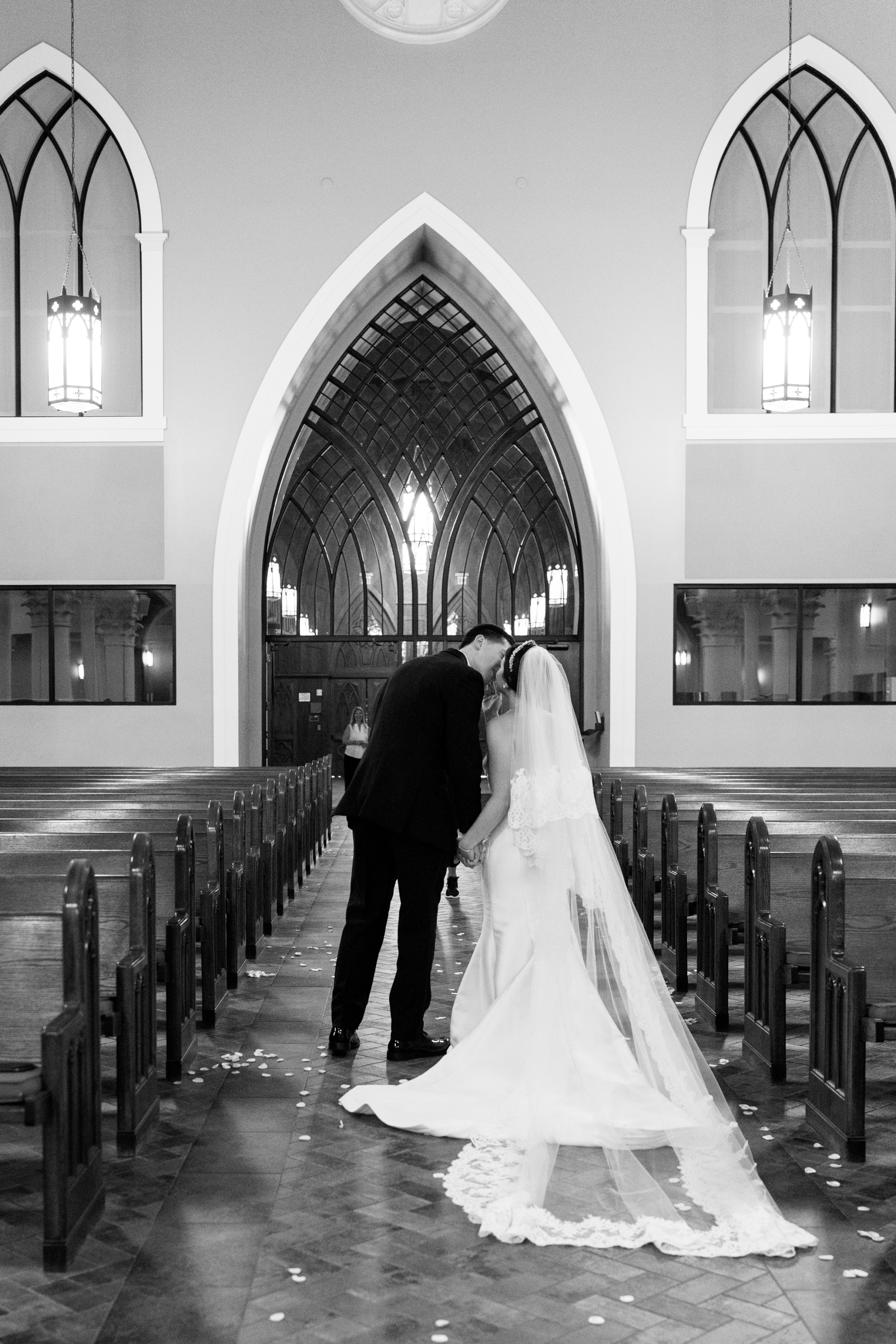 black and white wedding picture of bride and groom exiting chapel