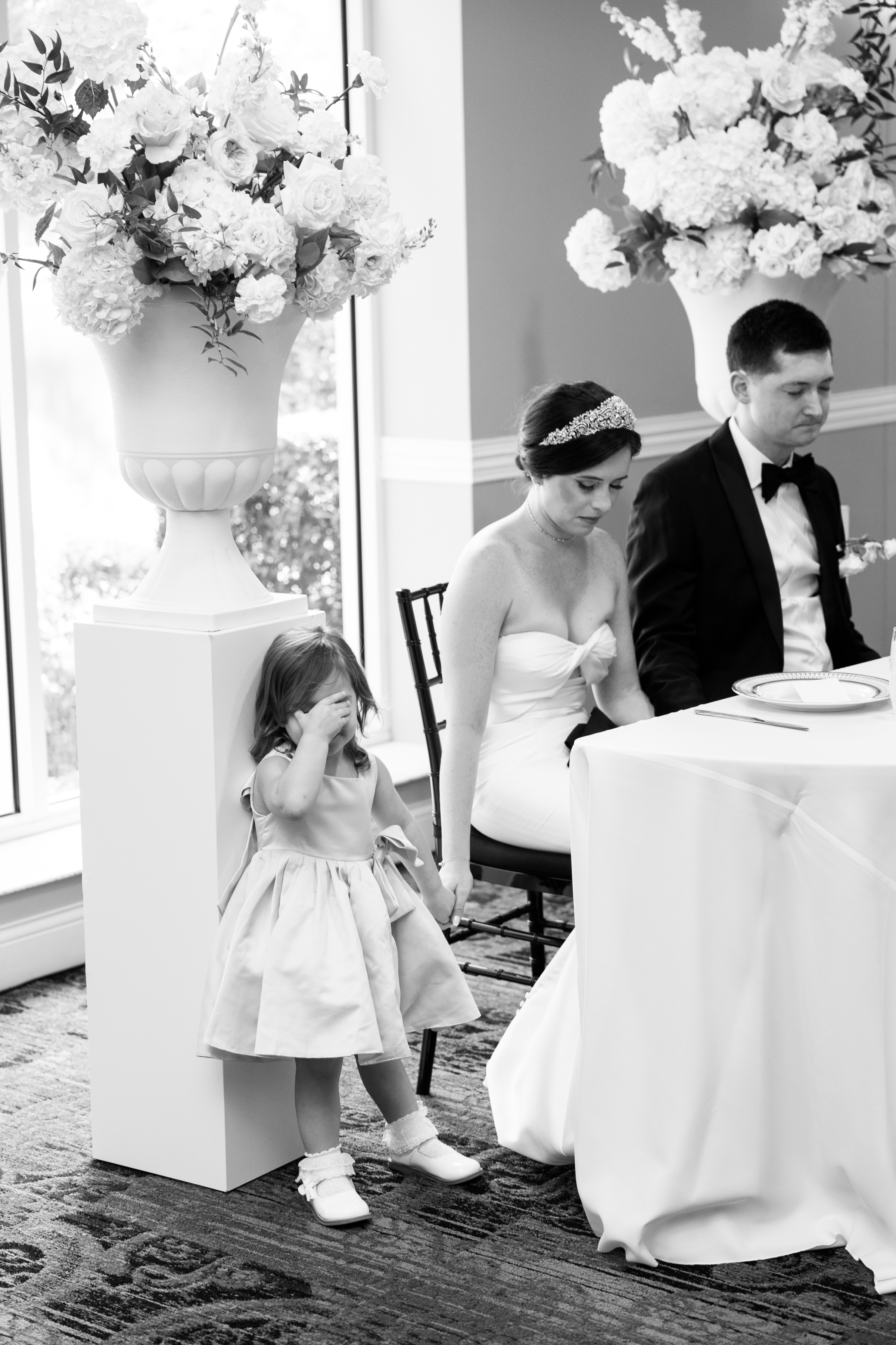 black and white picture of groom and bride saying prayer during wedding reception