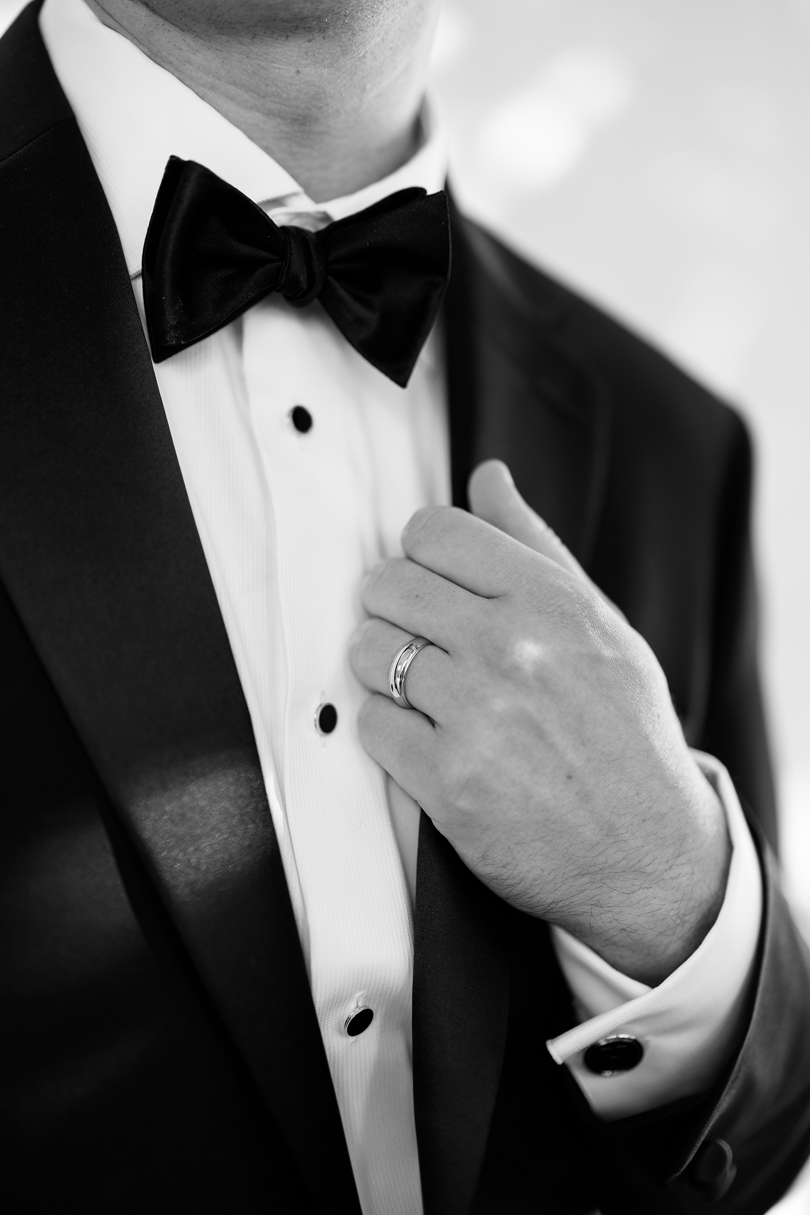close up of groom's tux and ring