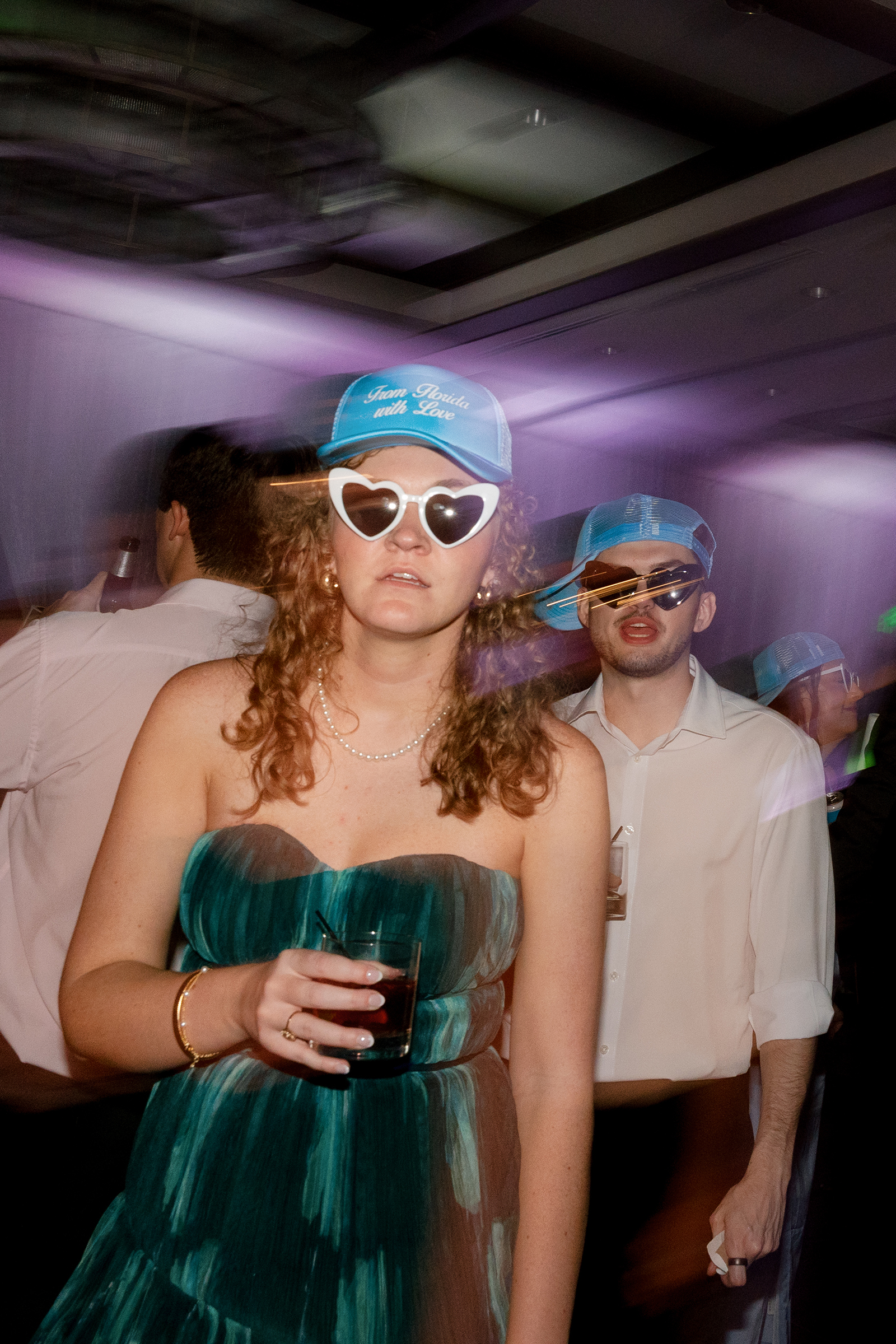 wedding guests during wedding reception wearing party hats and sunglasses