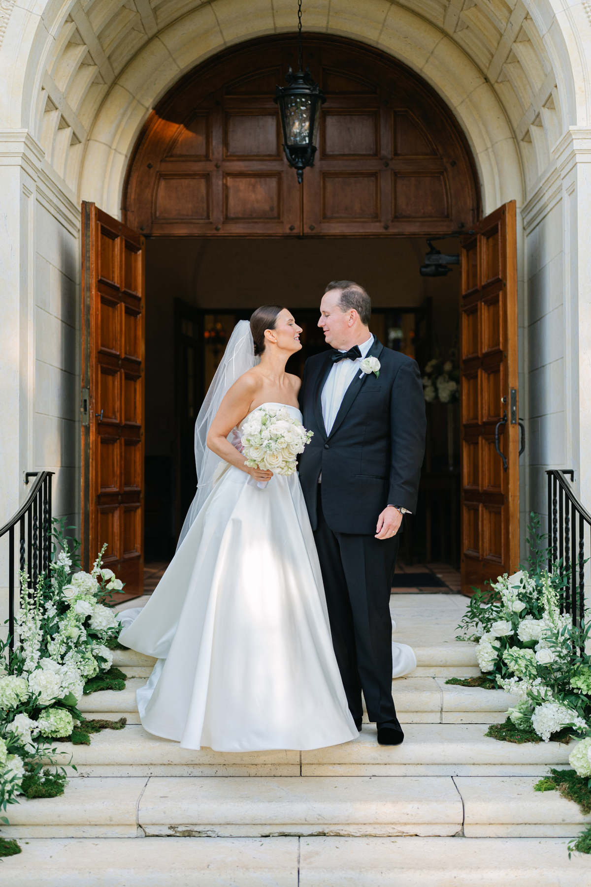 bride and groom on stairs outside knowles chapel at rollins college