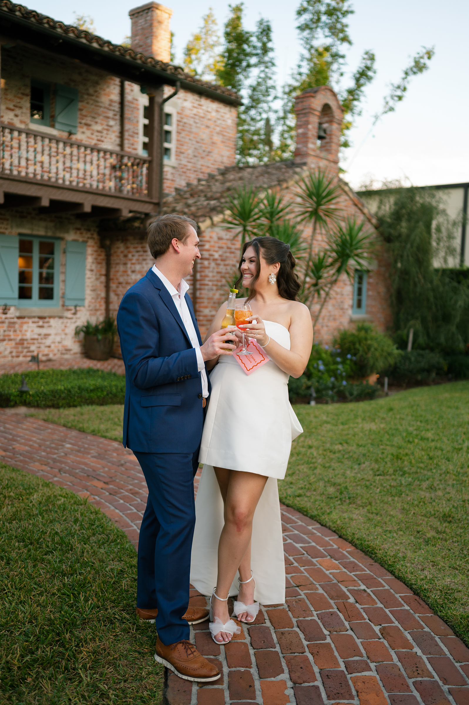 bride and groom holding cocktails at rehearsal dinner