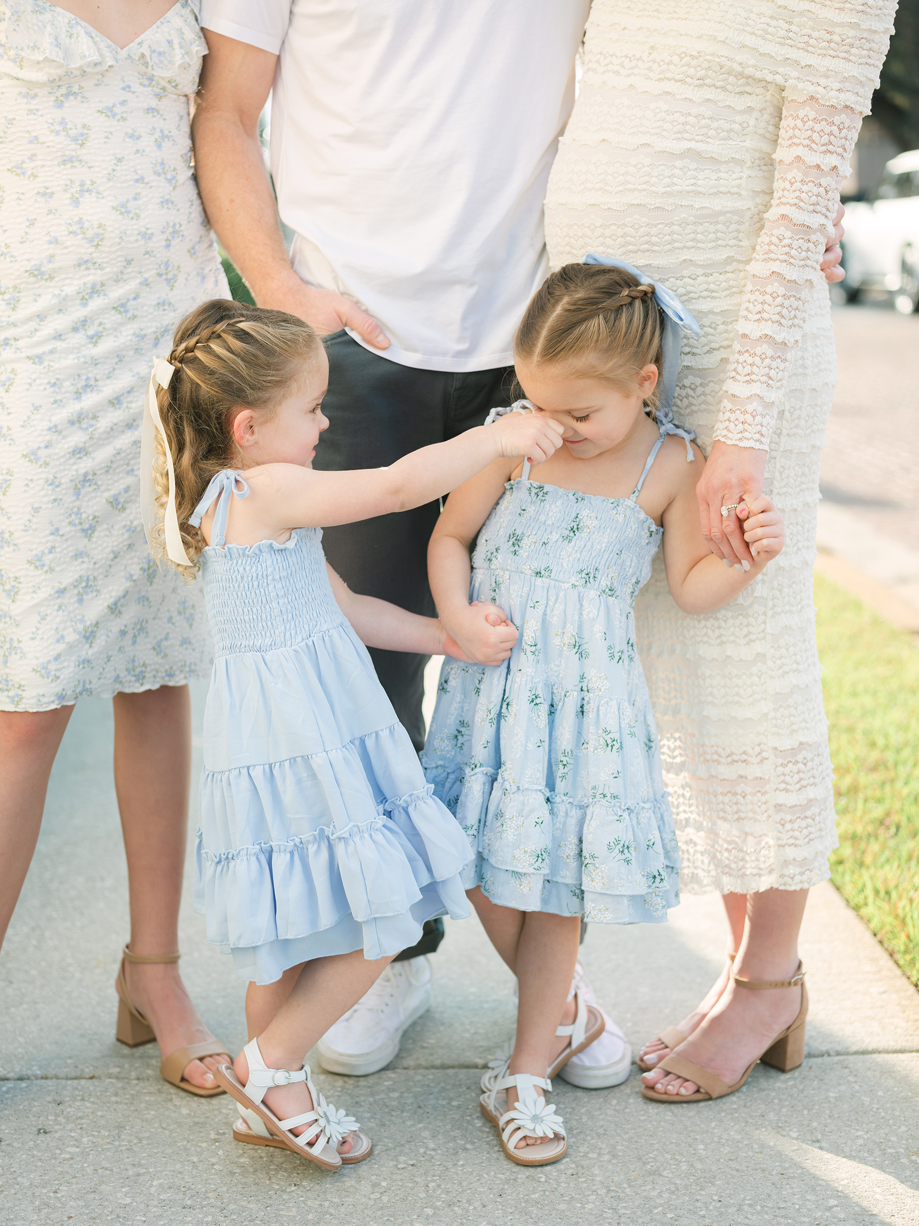 girls wearing muted blue sundresses with matching white sandals and hair bows