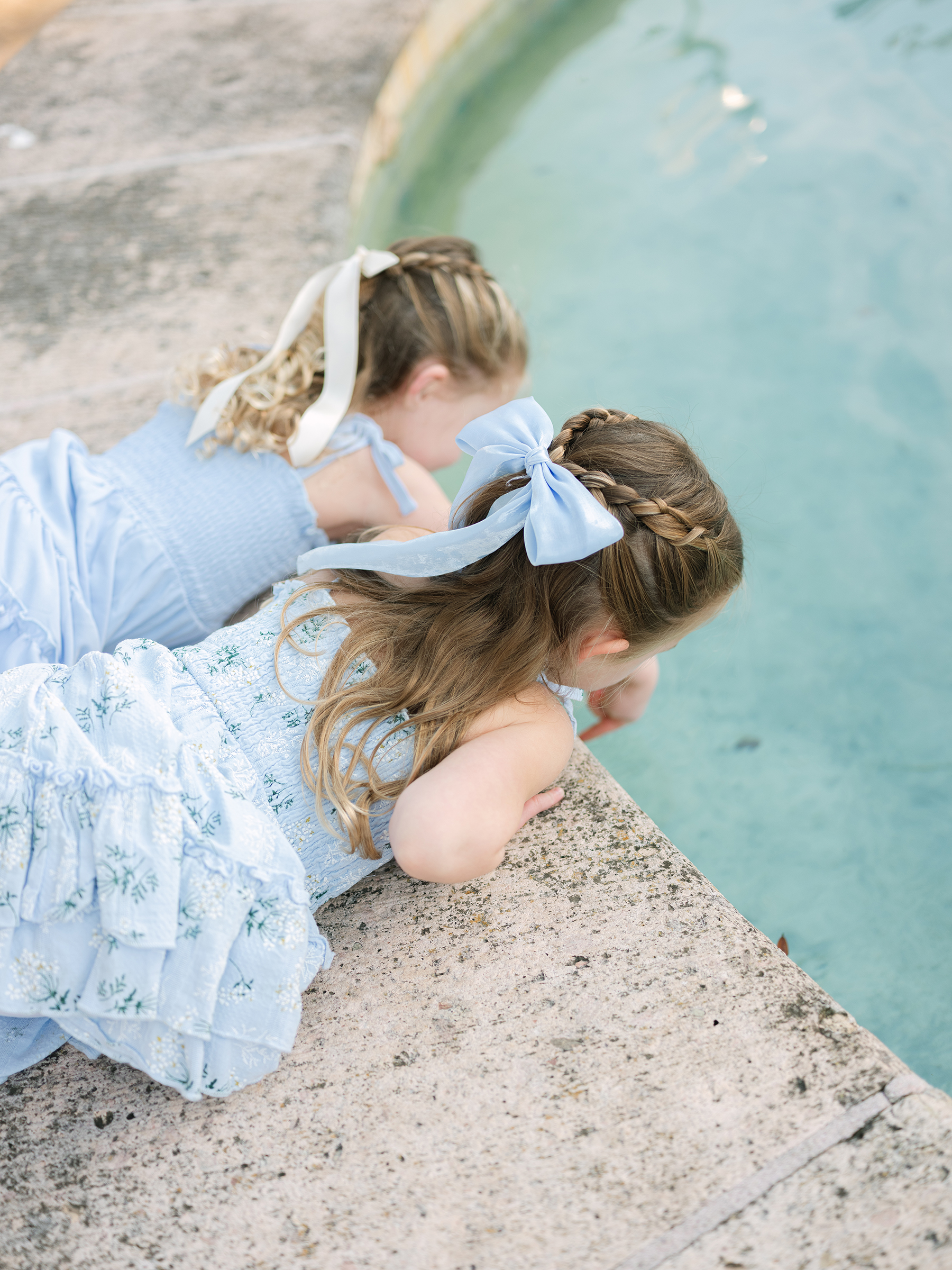 girls looking into water fountain
