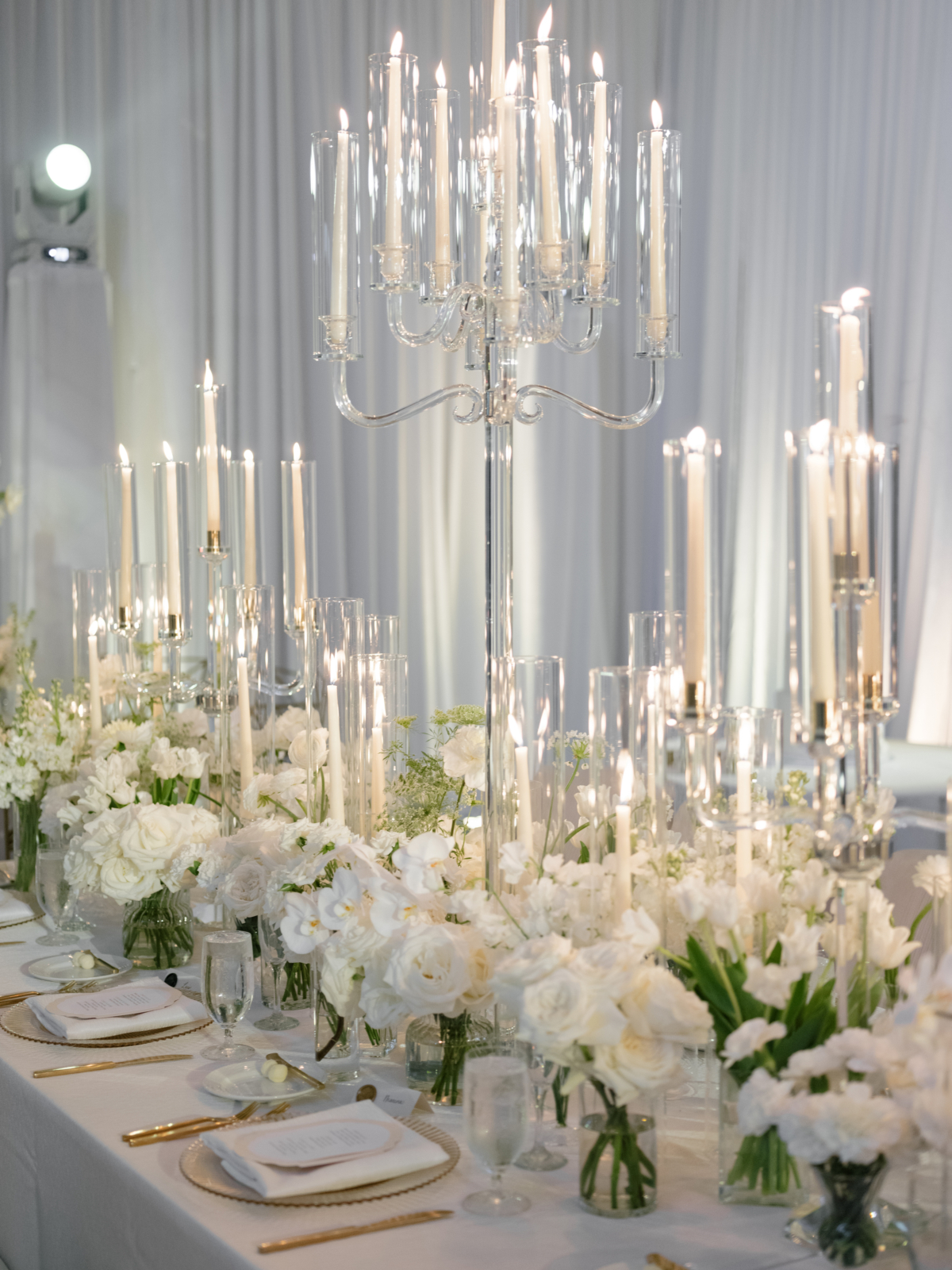 Crystal candelabra with ivory tapers rising above white roses and tulips on the reception table at Isleworth.