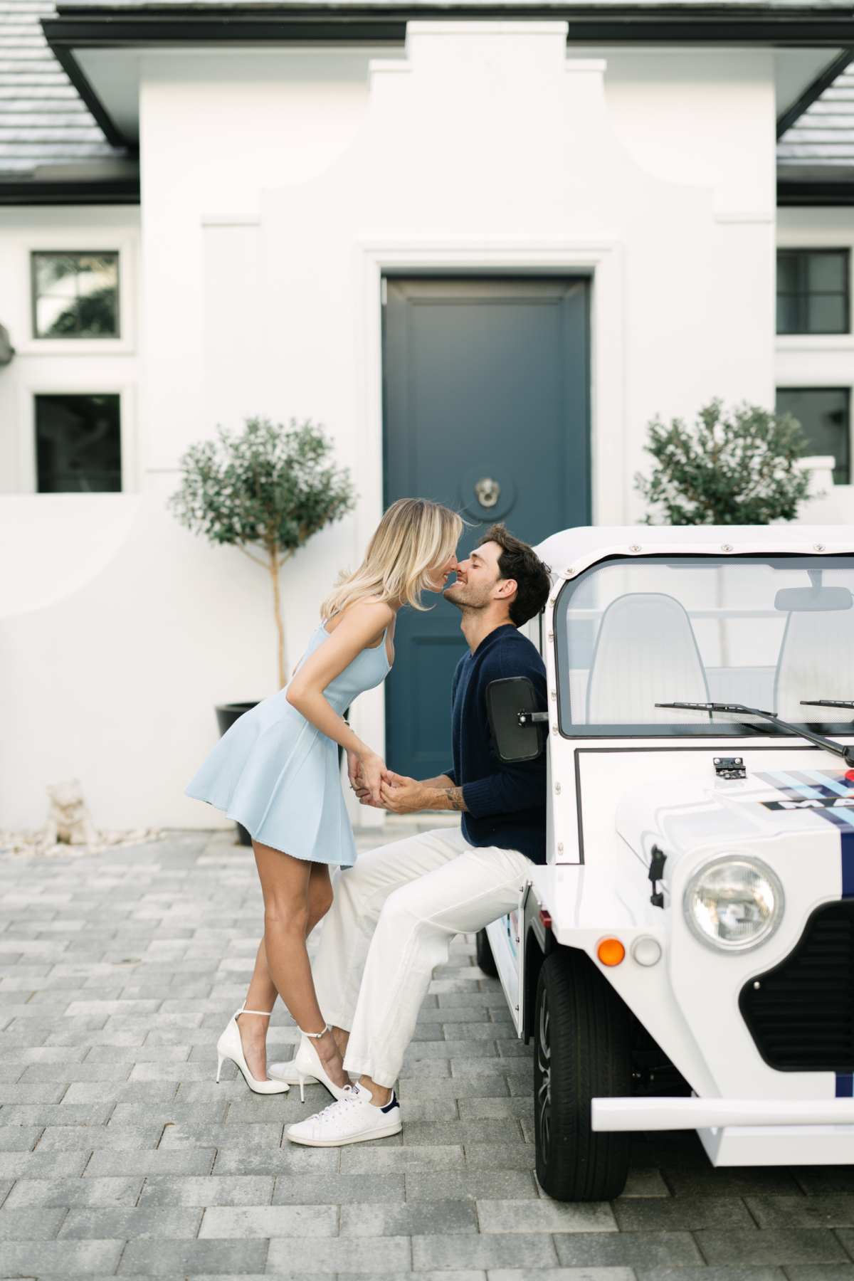 Lauren leaning in to kiss Joao as he sits on a white Moke in front of their home in Winter Park.