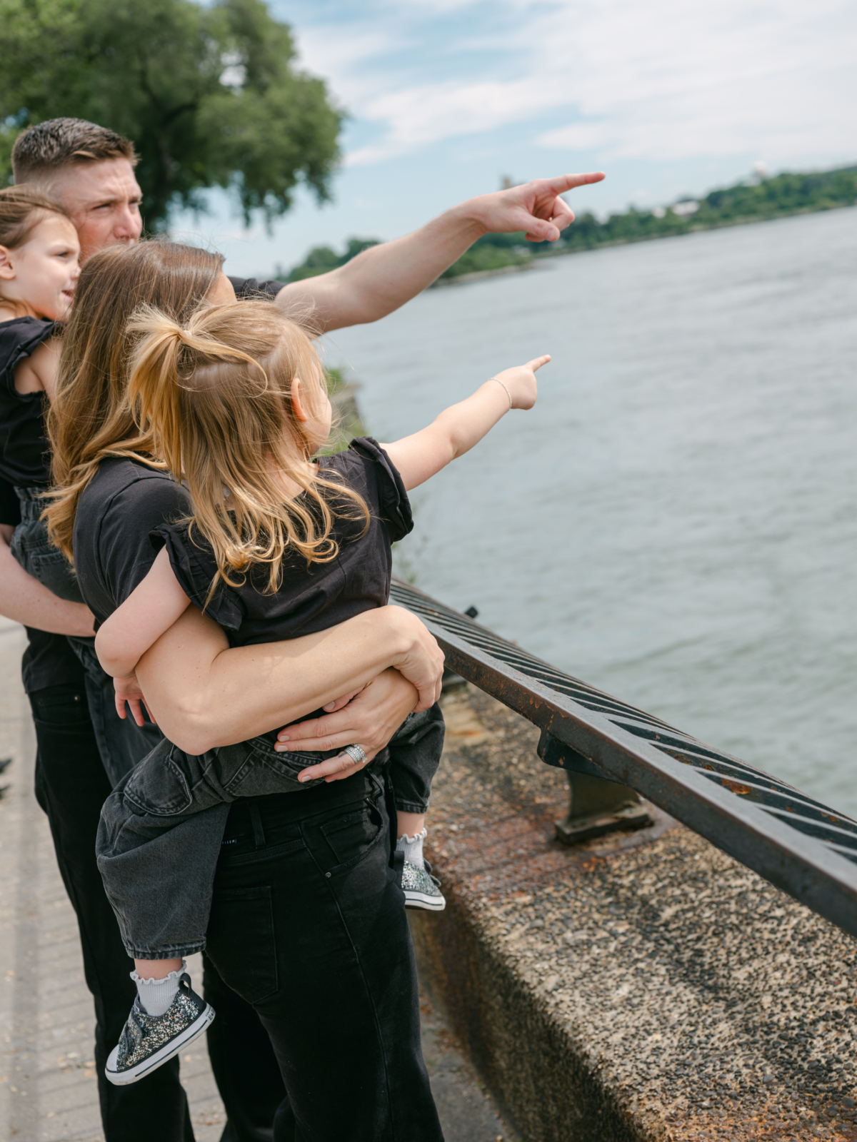 Nicole, Ryan and the girls point out at the boats on the East River from the promenade.